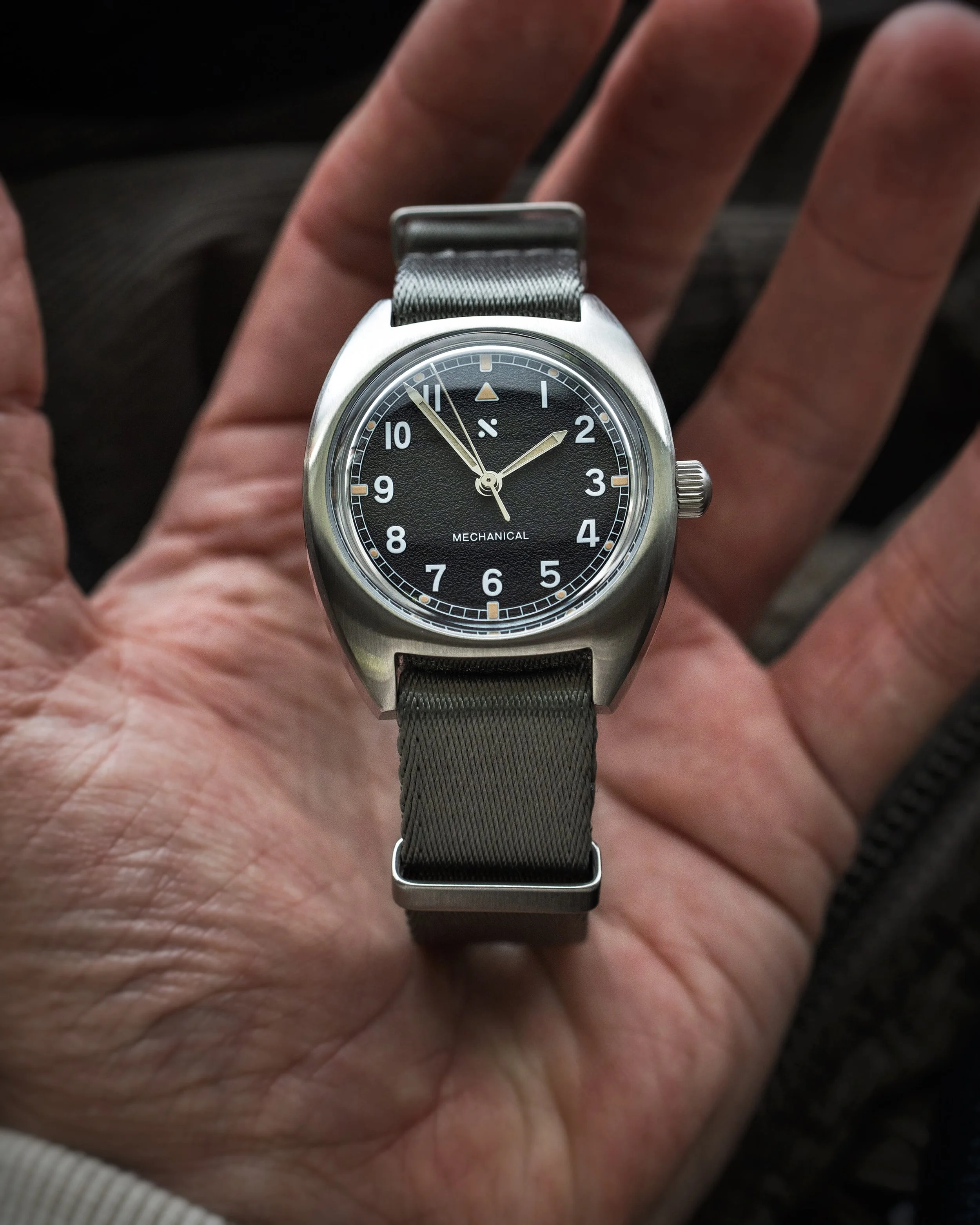 Namoki Mods NMK21 pilot watch shown in hand on a grey NATO strap