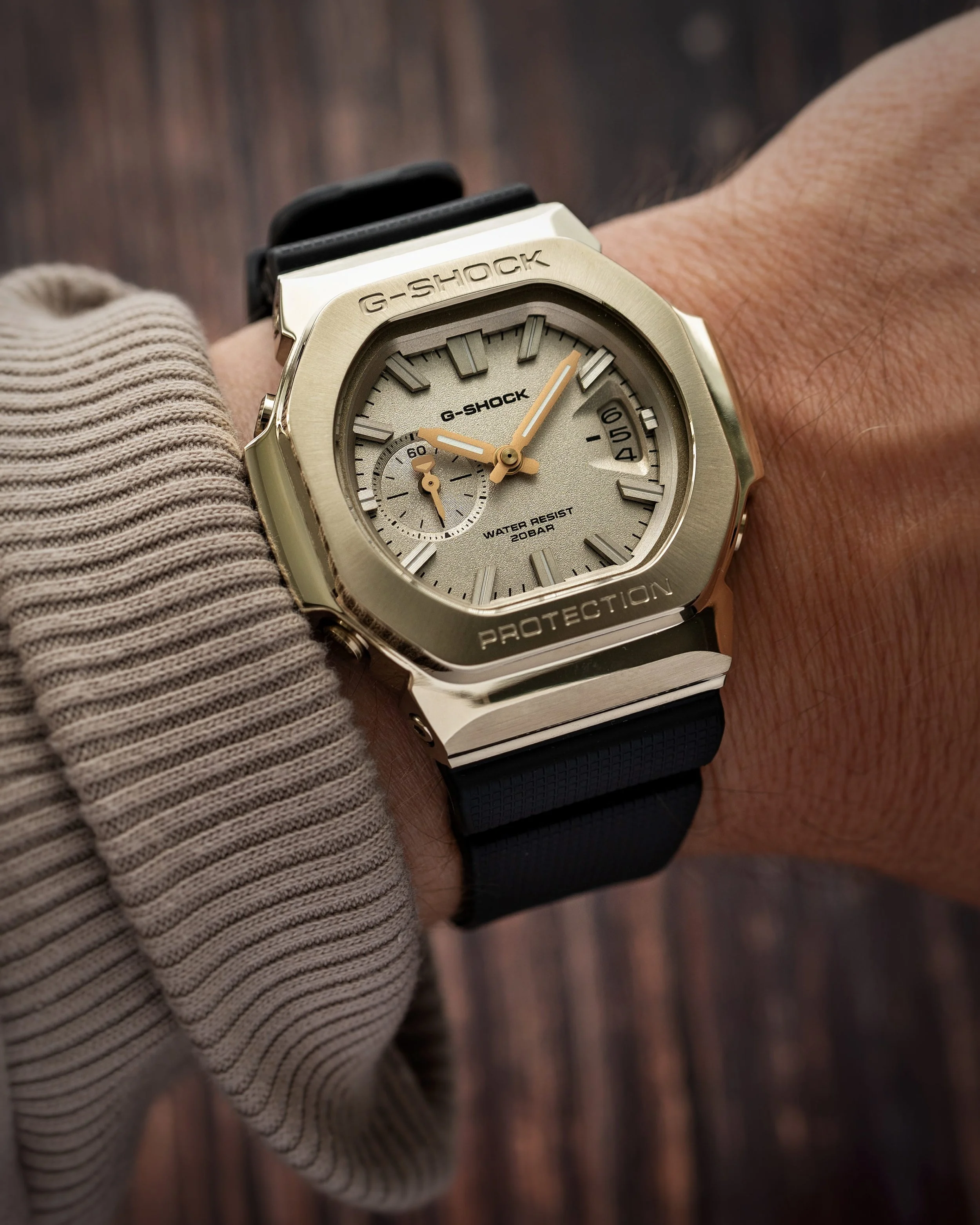 Casio G-SHOCK GMC-2500G-9A CasioNaut worn on the wrist, featuring a brushed champagne-gold metal bezel, textured gold dial, polished case edges and black resin strap.