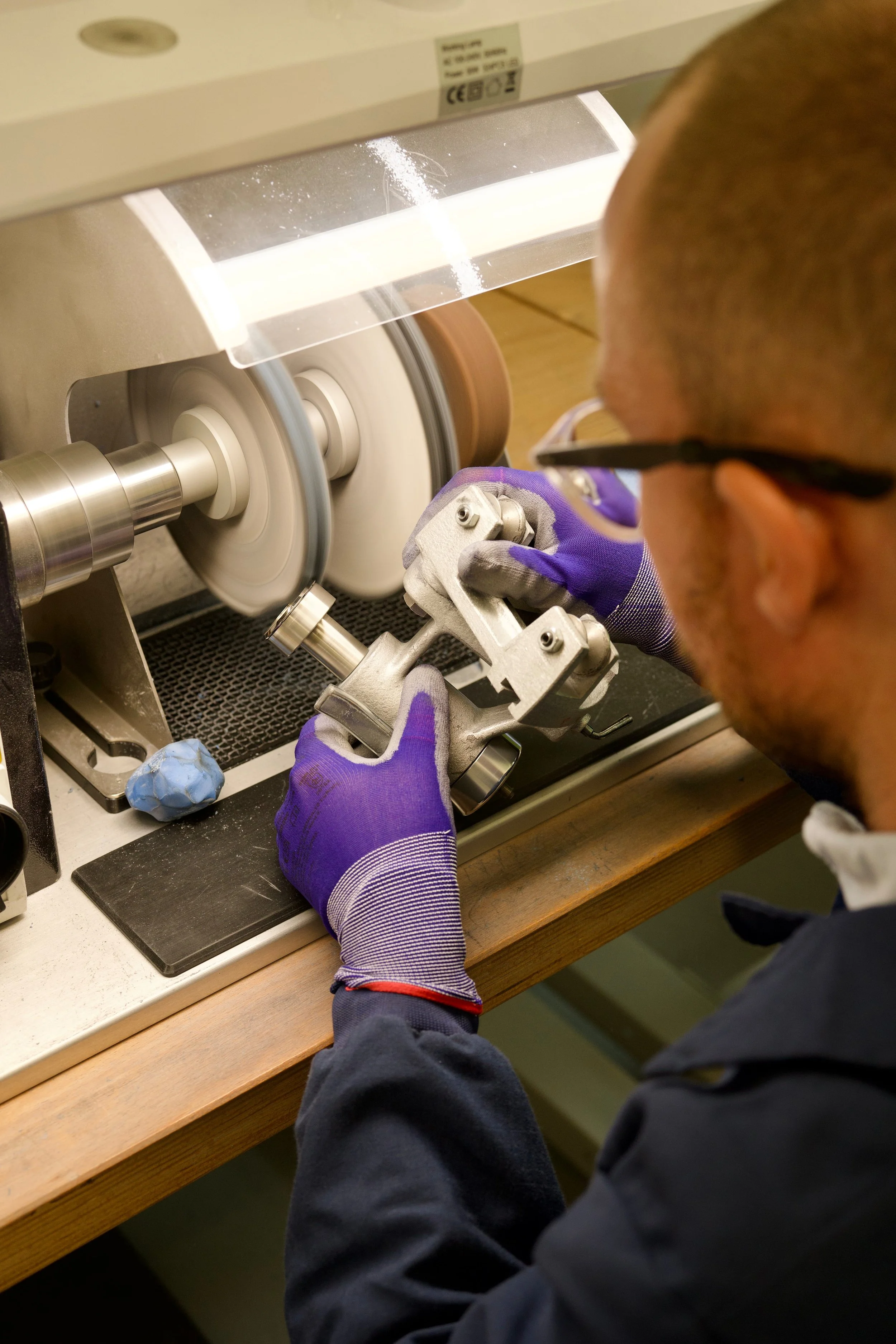Watchmaker polishing a watch case at the Seiko UK service centre.