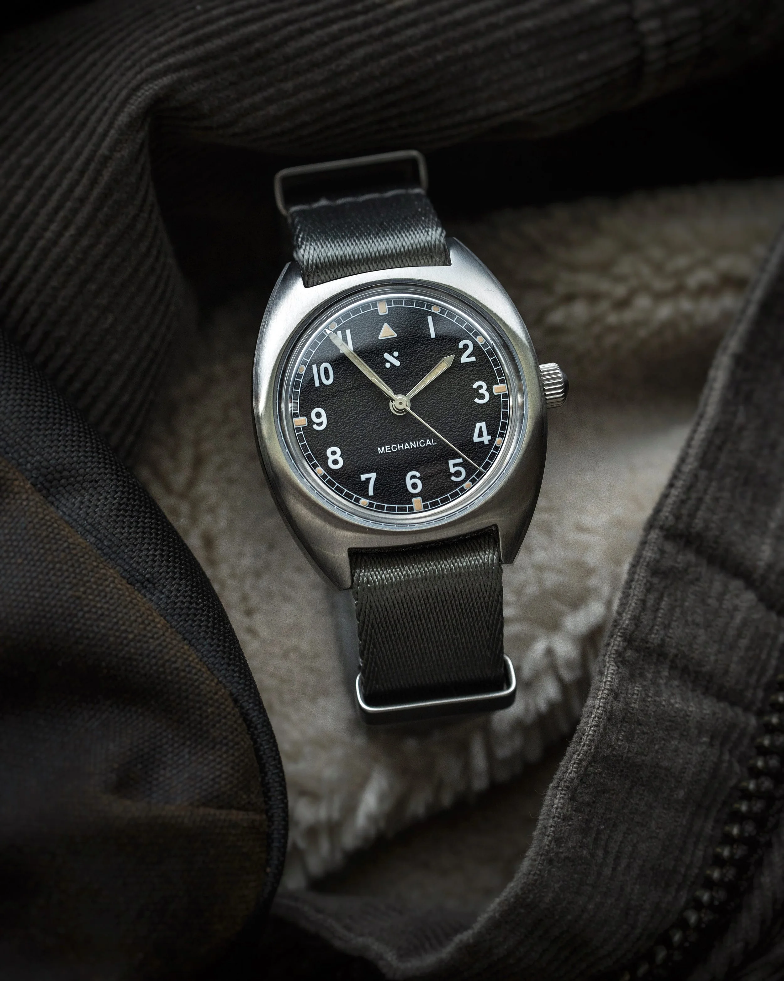 Namoki Mods NMK21 pilot watch with black dial and grey NATO strap in a styled hero shot