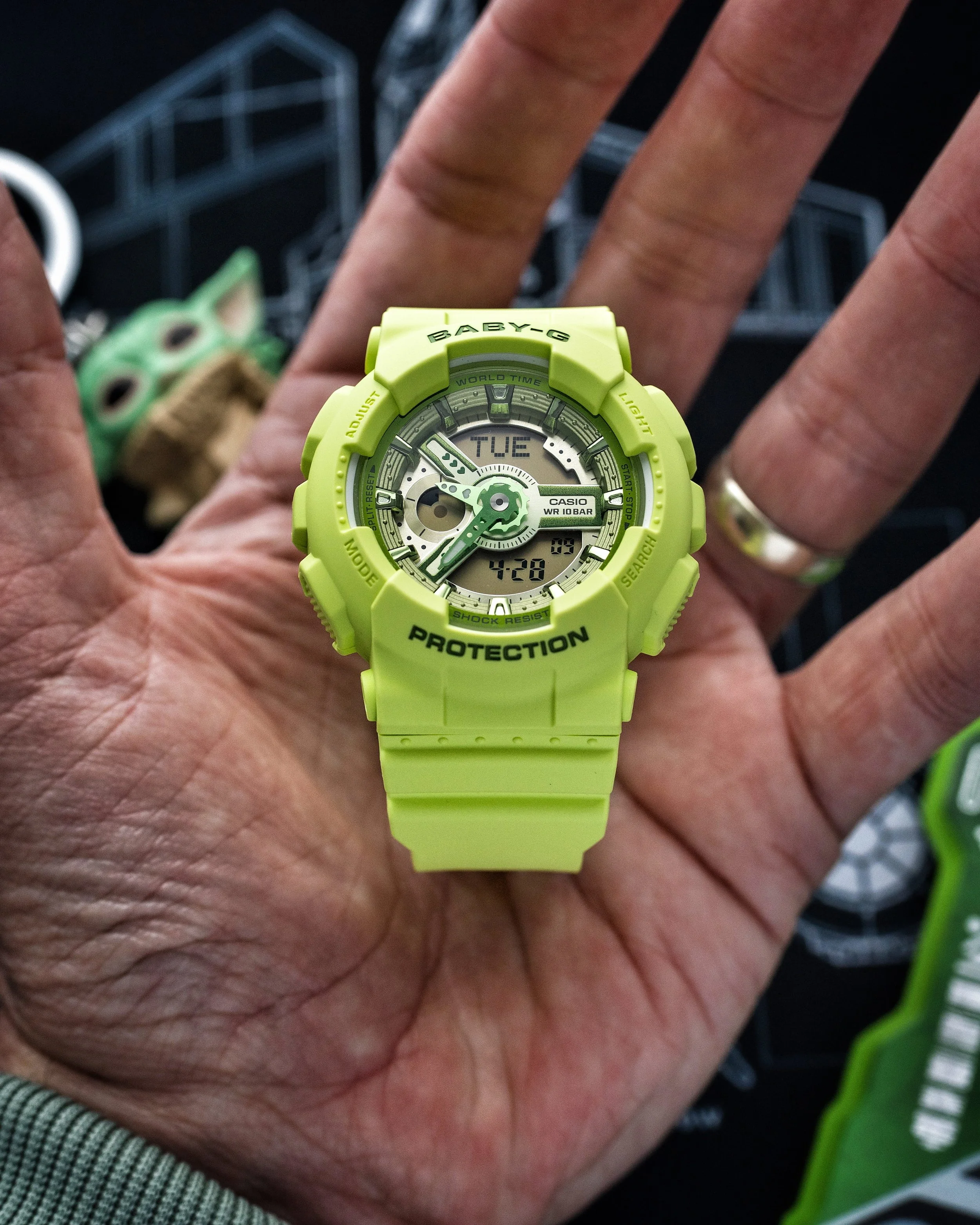 Close-up of the Baby-G BA-110 Grogu watch showing the vivid green resin case, layered dial and analogue digital display