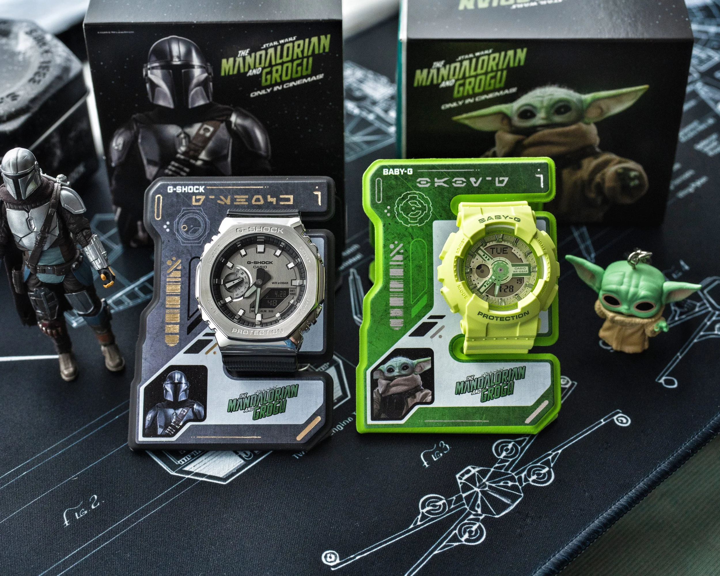 G-SHOCK Mandalorian GM-2100 and Baby-G Grogu BA-110 watches displayed with themed Star Wars packaging and magnetic ID stands