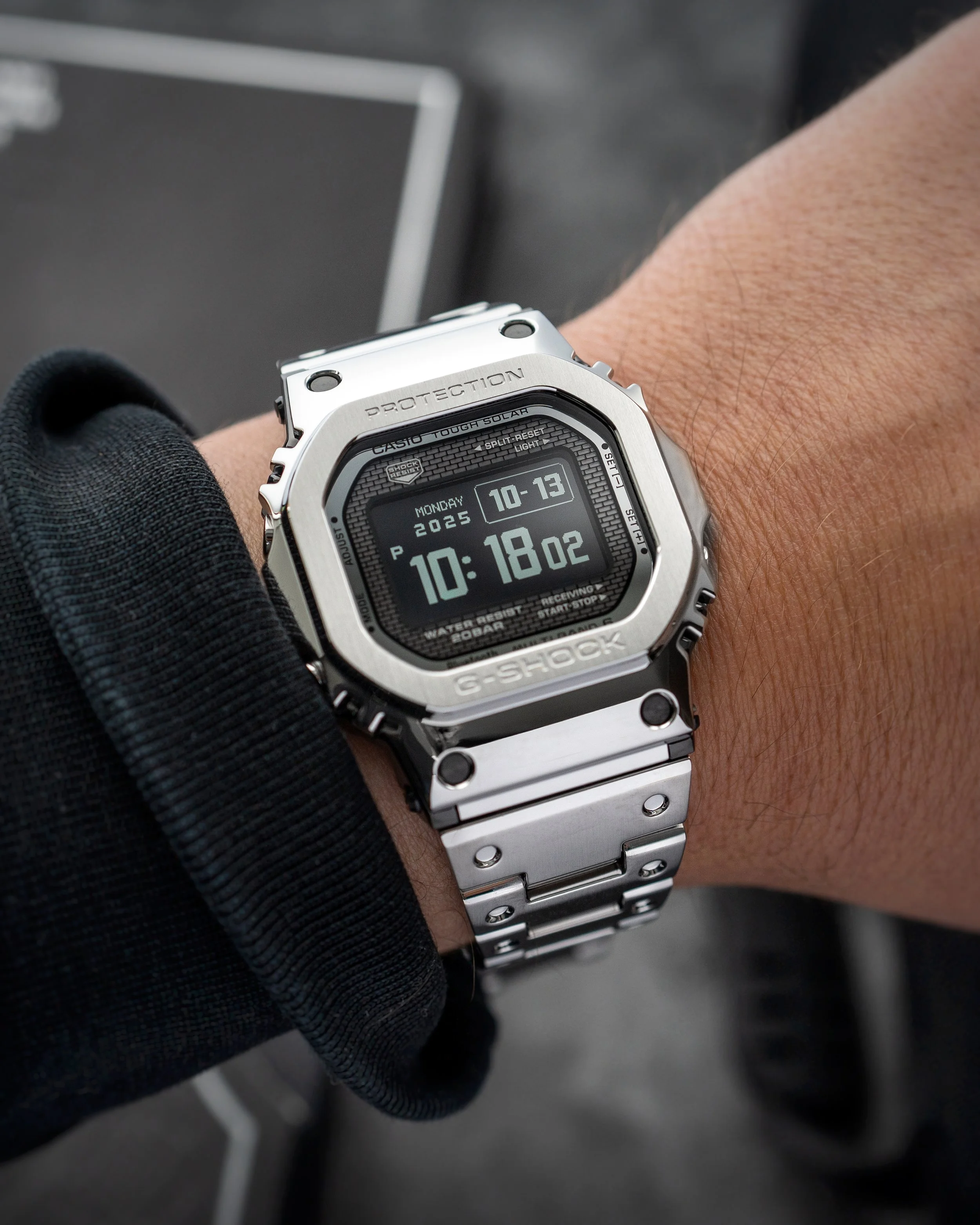 Full-metal stainless steel G-SHOCK square on wrist shown as a comparison to the lighter resin GW-BX5600