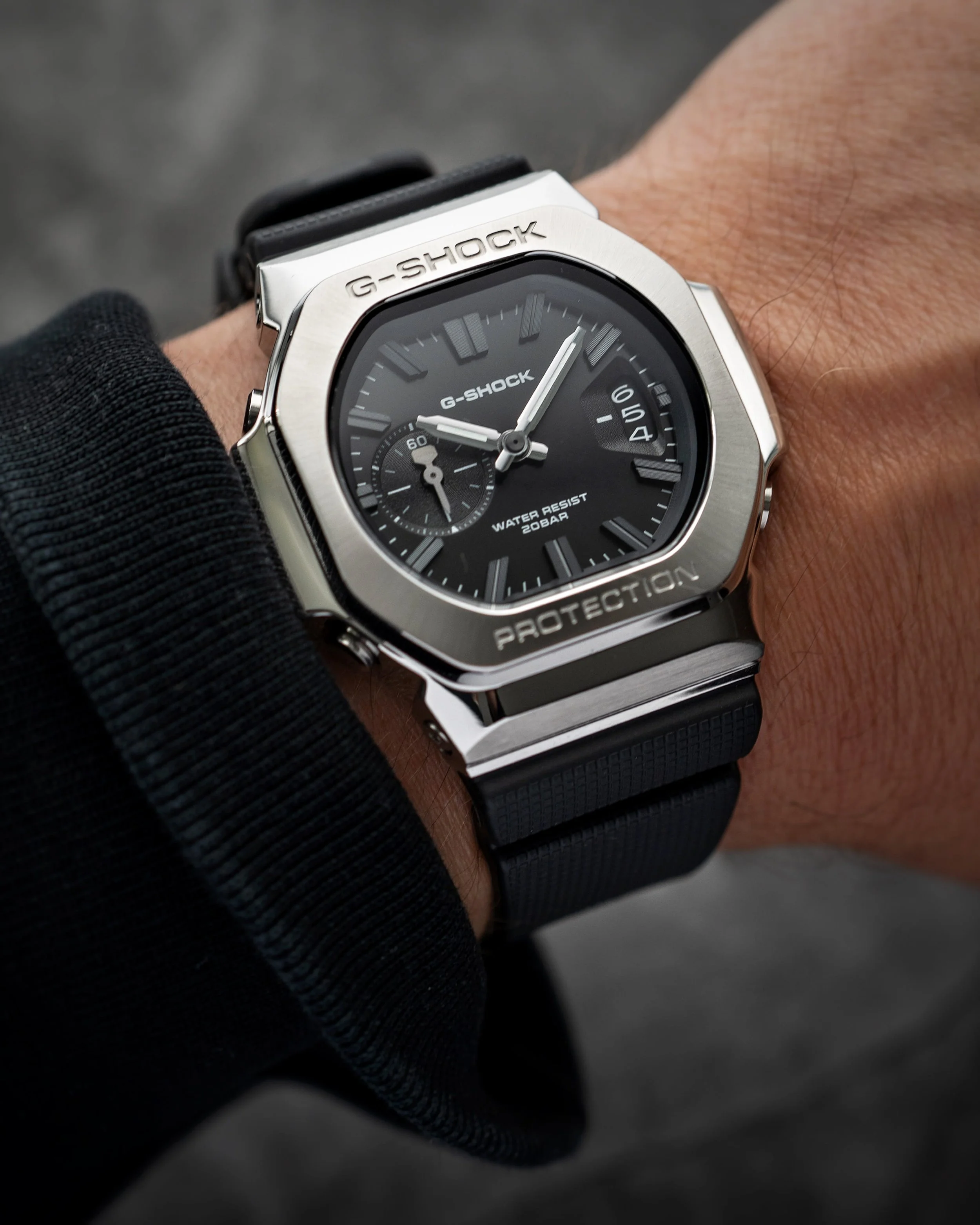 Casio G-SHOCK GMC-2500-1A CasioNaut worn on the wrist, featuring a black analogue dial, brushed stainless steel bezel, polished case edges and textured black resin strap.