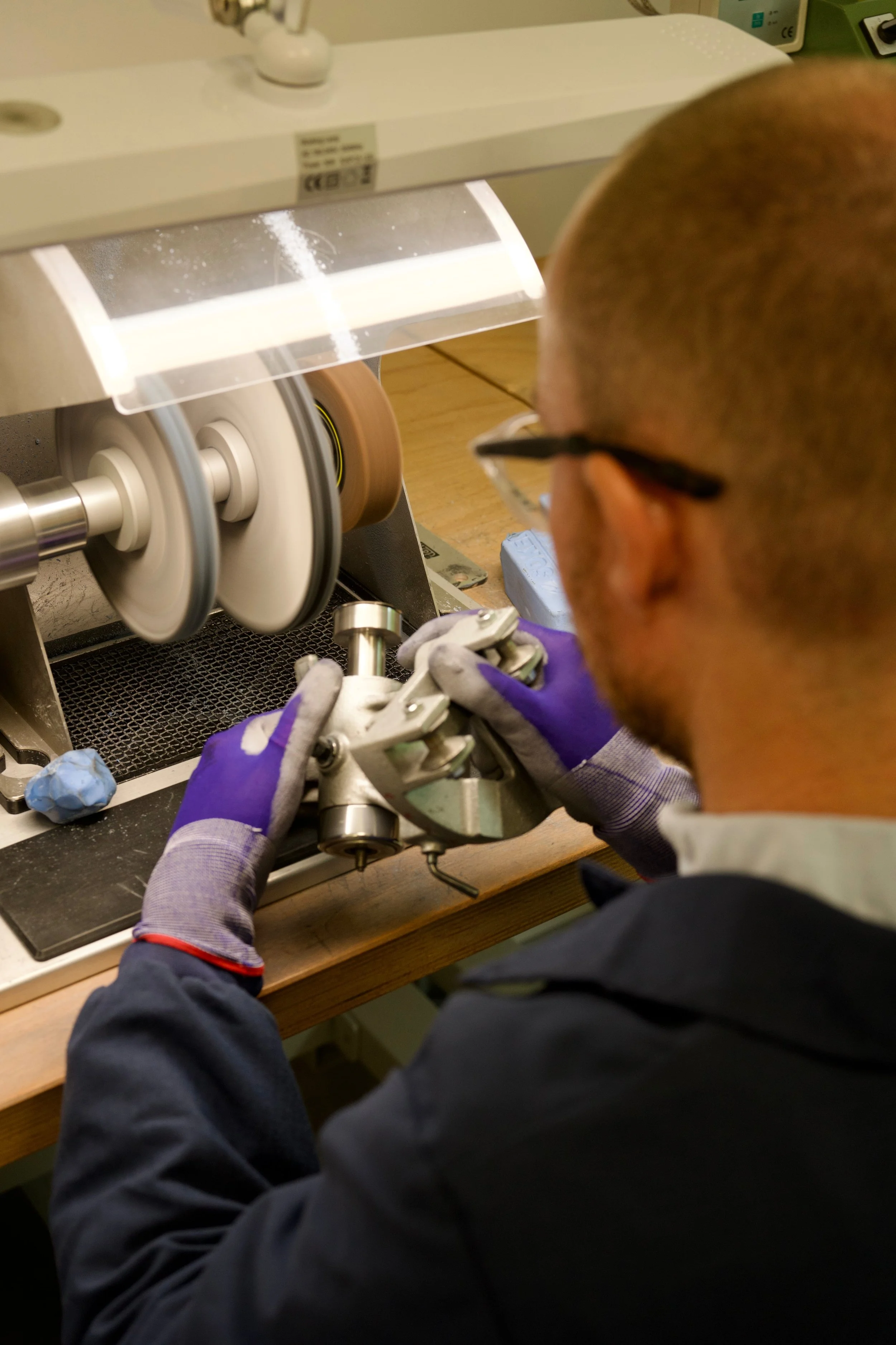 Watchmaker polishing a watch case during a refinishing demonstration at the Seiko UK workshop.