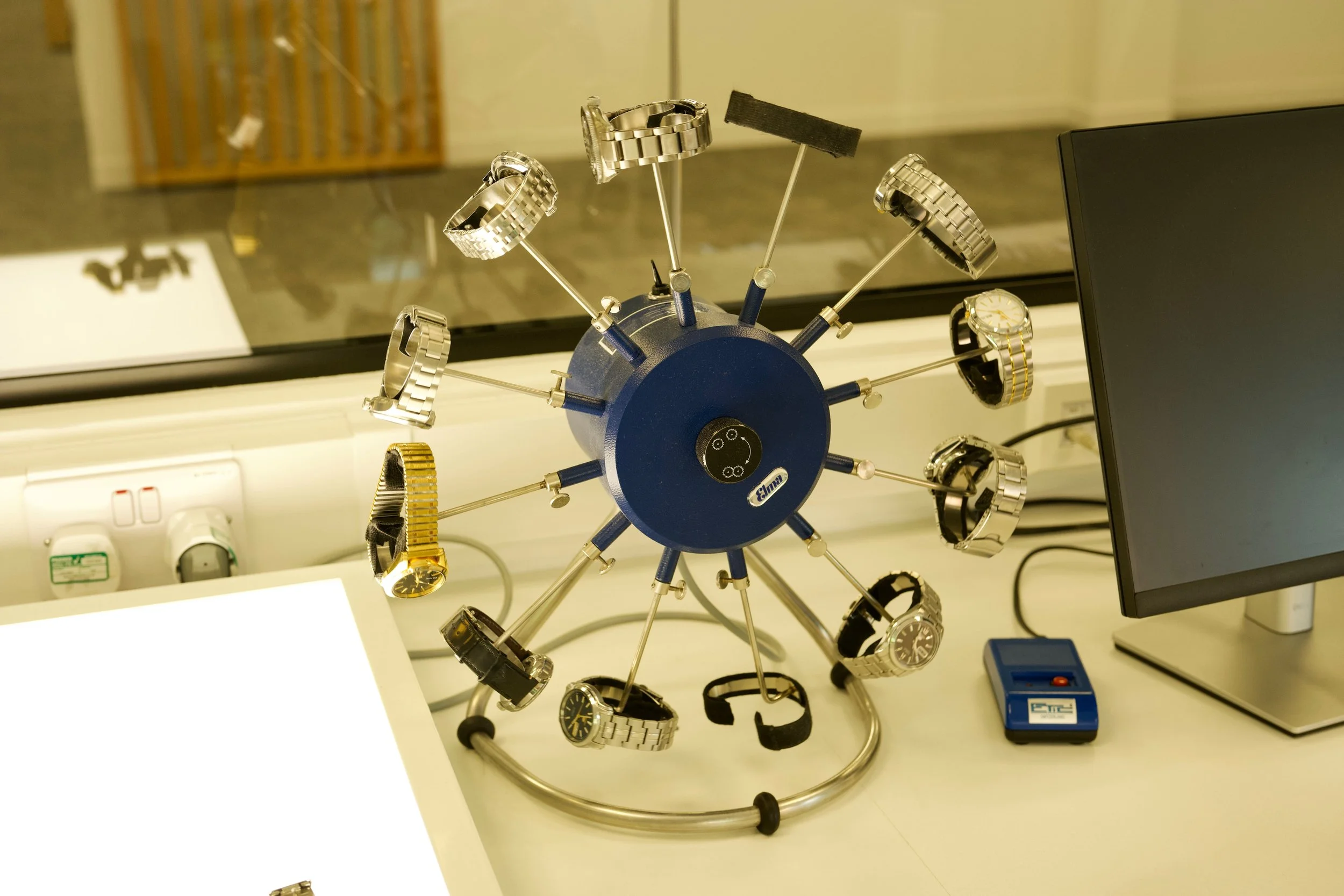 Multiple watches mounted on a testing machine inside the Seiko UK service centre.
