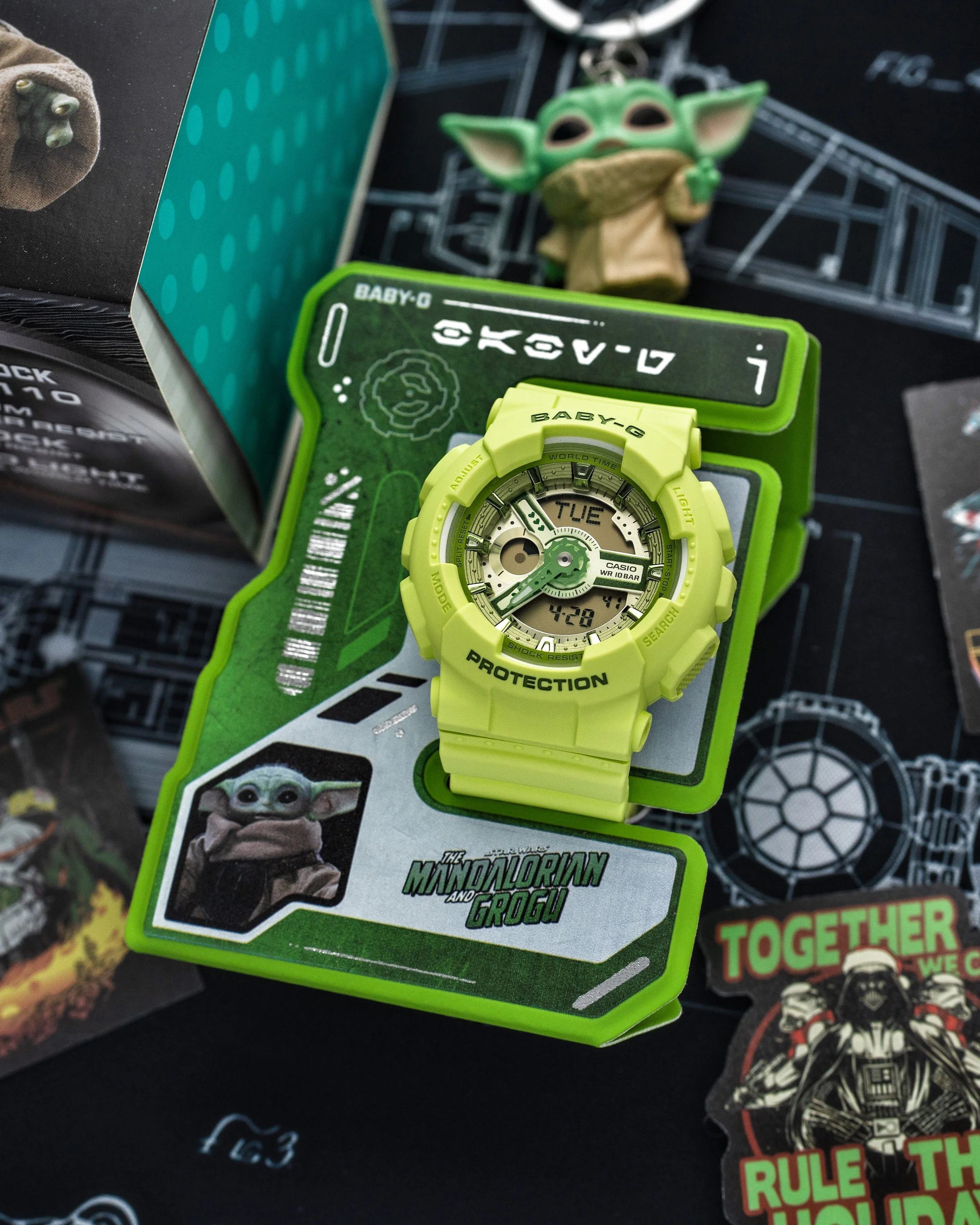 Baby-G BA-110 Grogu watch in vivid green displayed on its Mandalorian and Grogu magnetic ID stand