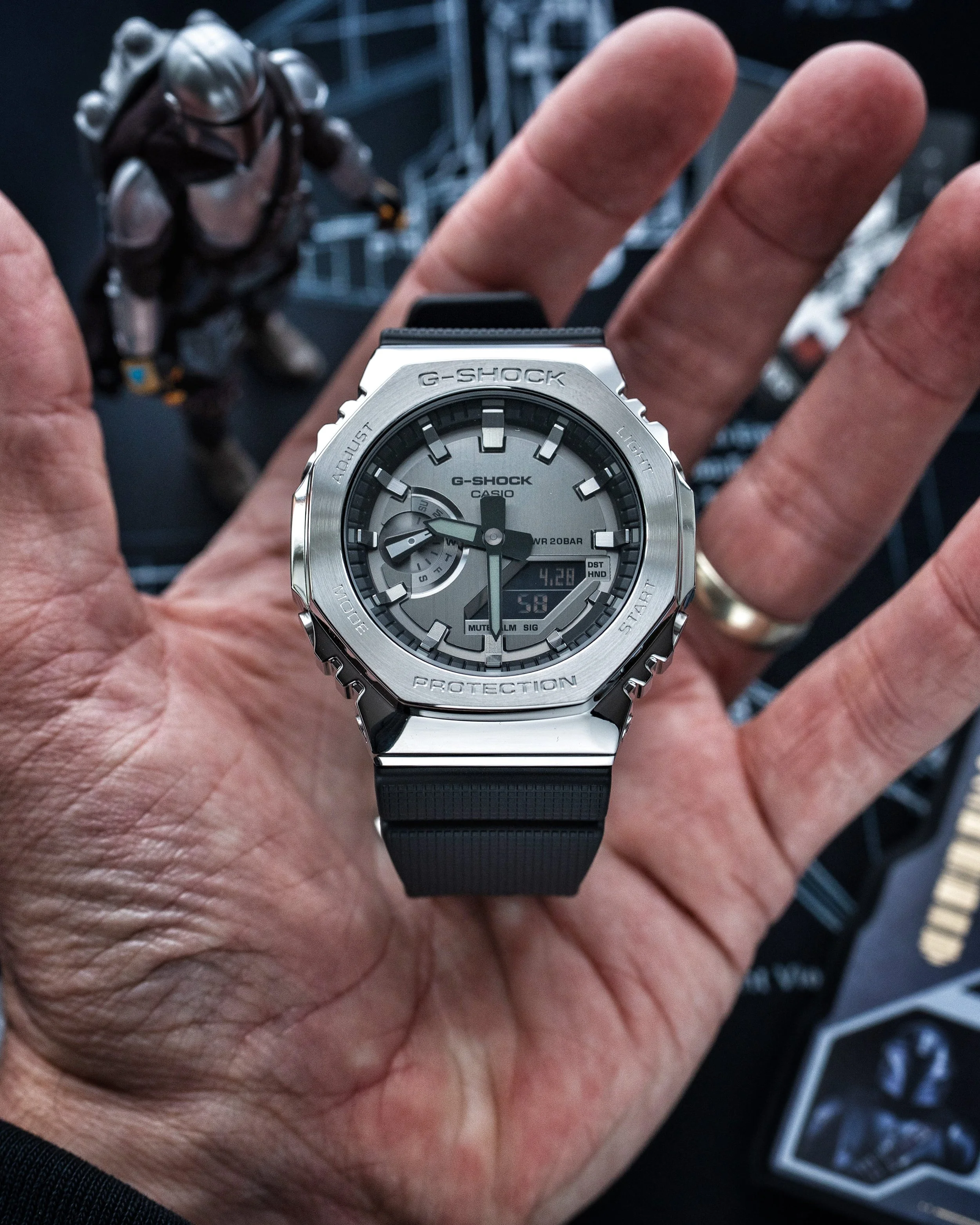 Close-up of the G-SHOCK GM-2100 Mandalorian watch showing the Beskar-inspired metal bezel, grey dial and black resin strap