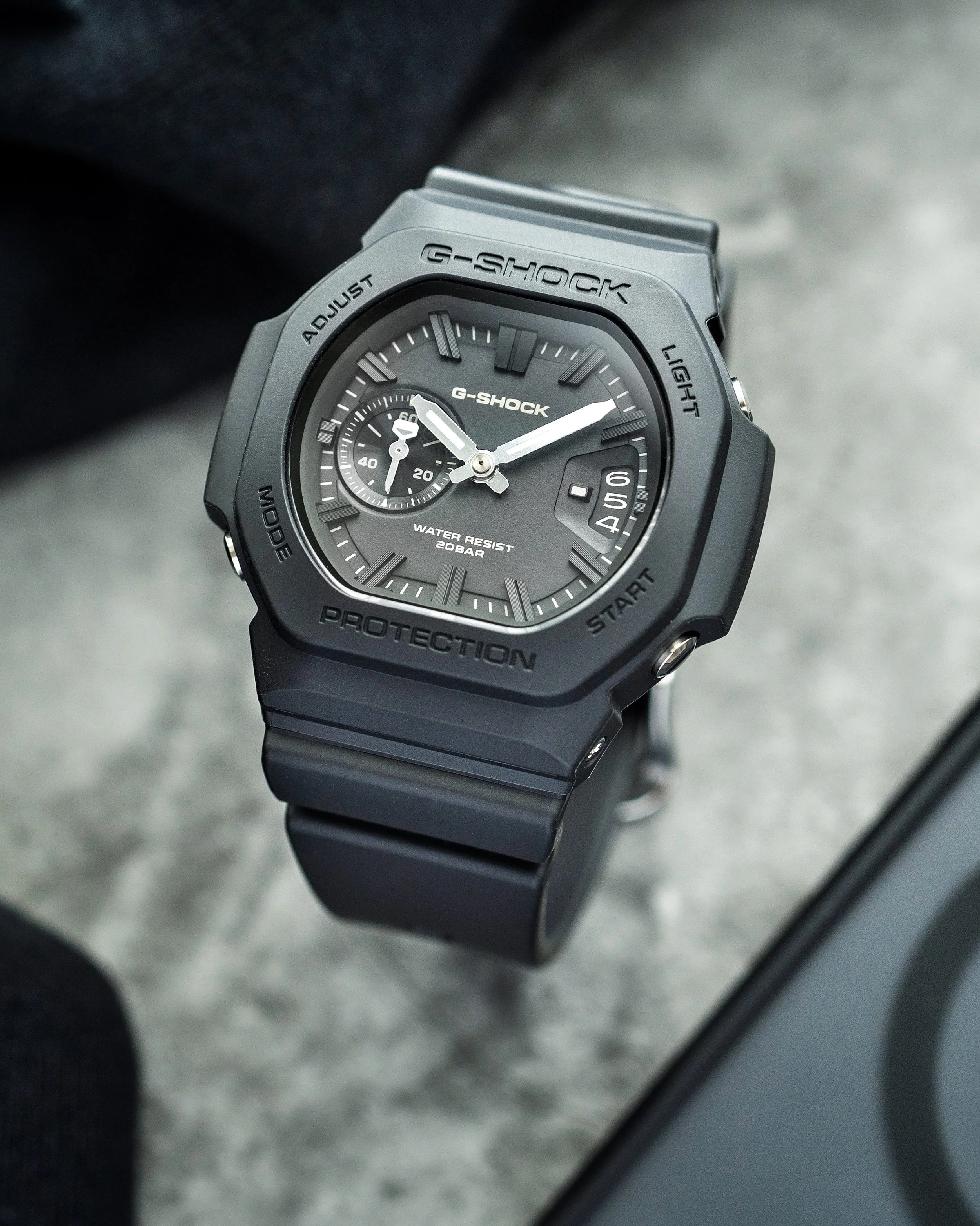 Casio G-SHOCK GAC-2500-1A CasioNaut featuring a black resin case and strap, dark analogue dial, contrasting silver-tone hands and raised hour markers, photographed on a grey surface.
