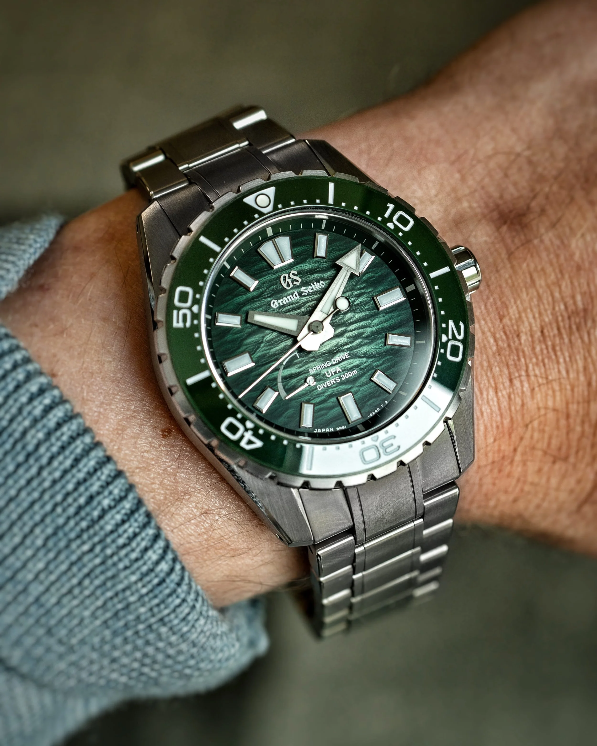 Grand Seiko SLGB025 Ushio 300 Diver on wrist with green textured dial and titanium bracelet.