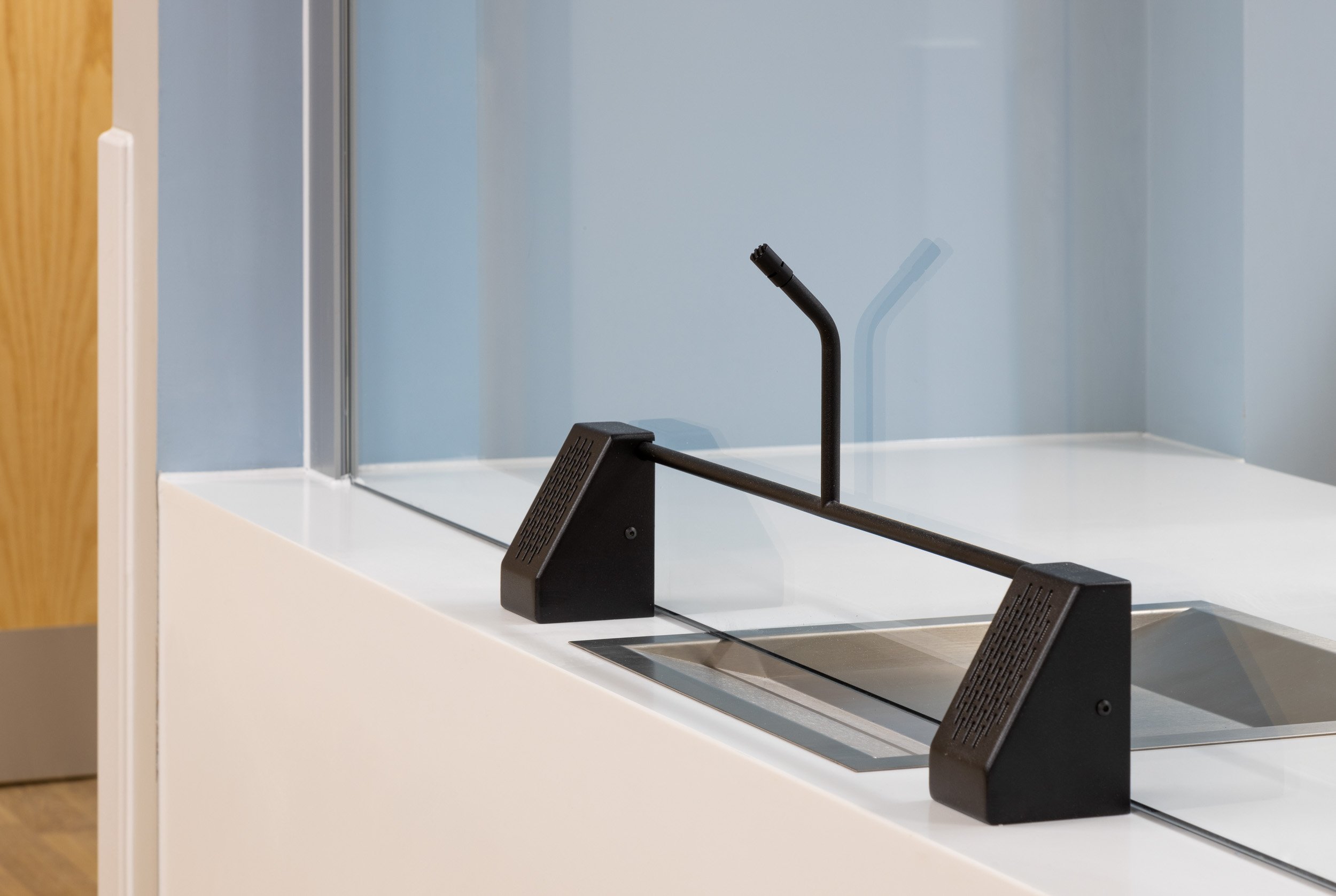 A glass display case with a black handle and a black mechanical arm inside.