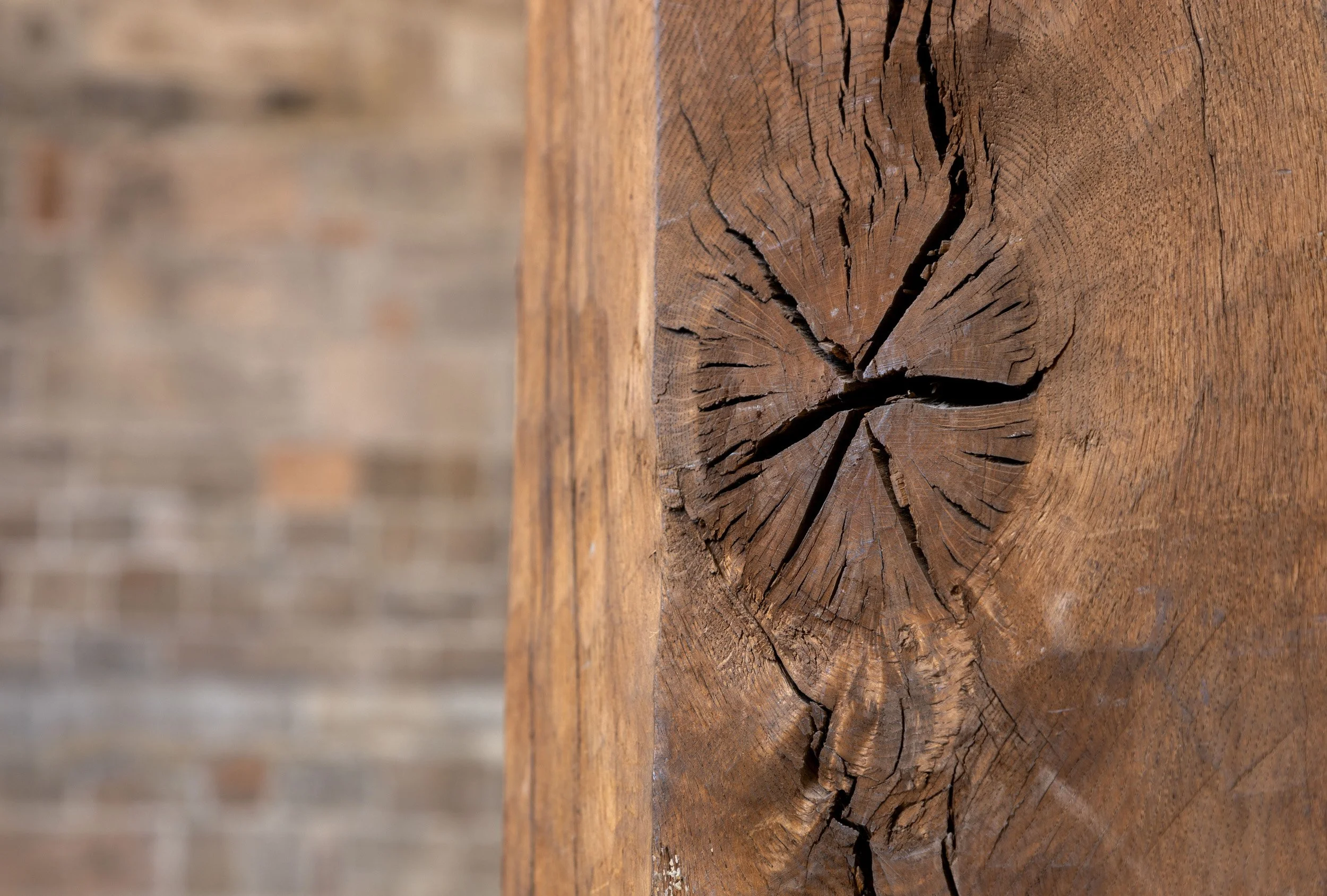 Close-up of a weathered wooden surface with visible cracks and grain.