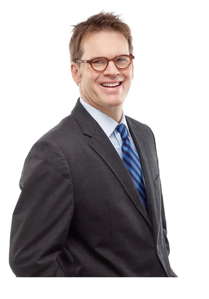 Black and white sketch of a man wearing glasses and a suit, smiling.