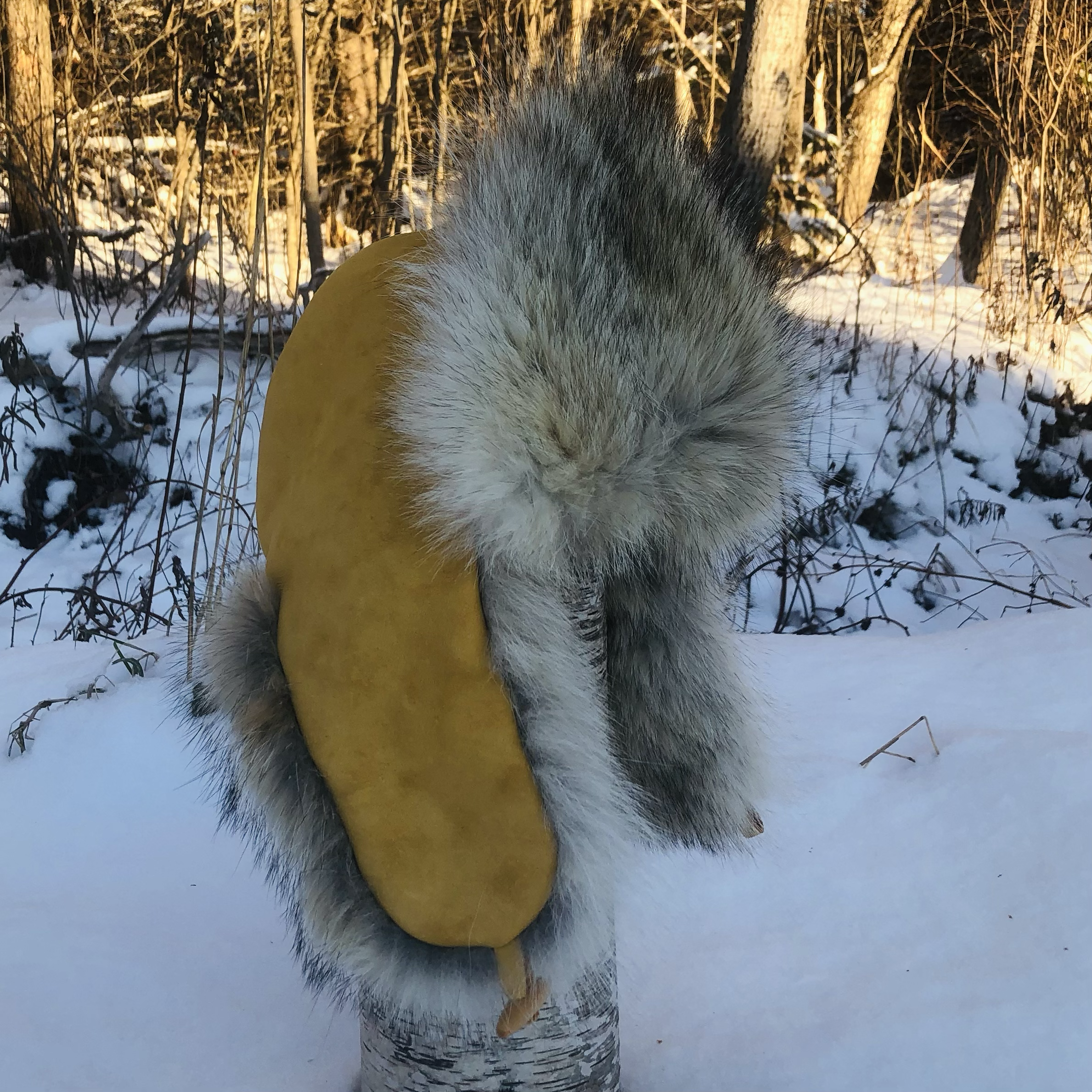 
Trapper coyote fur hat, yellow deer hide leather, toggle tie 