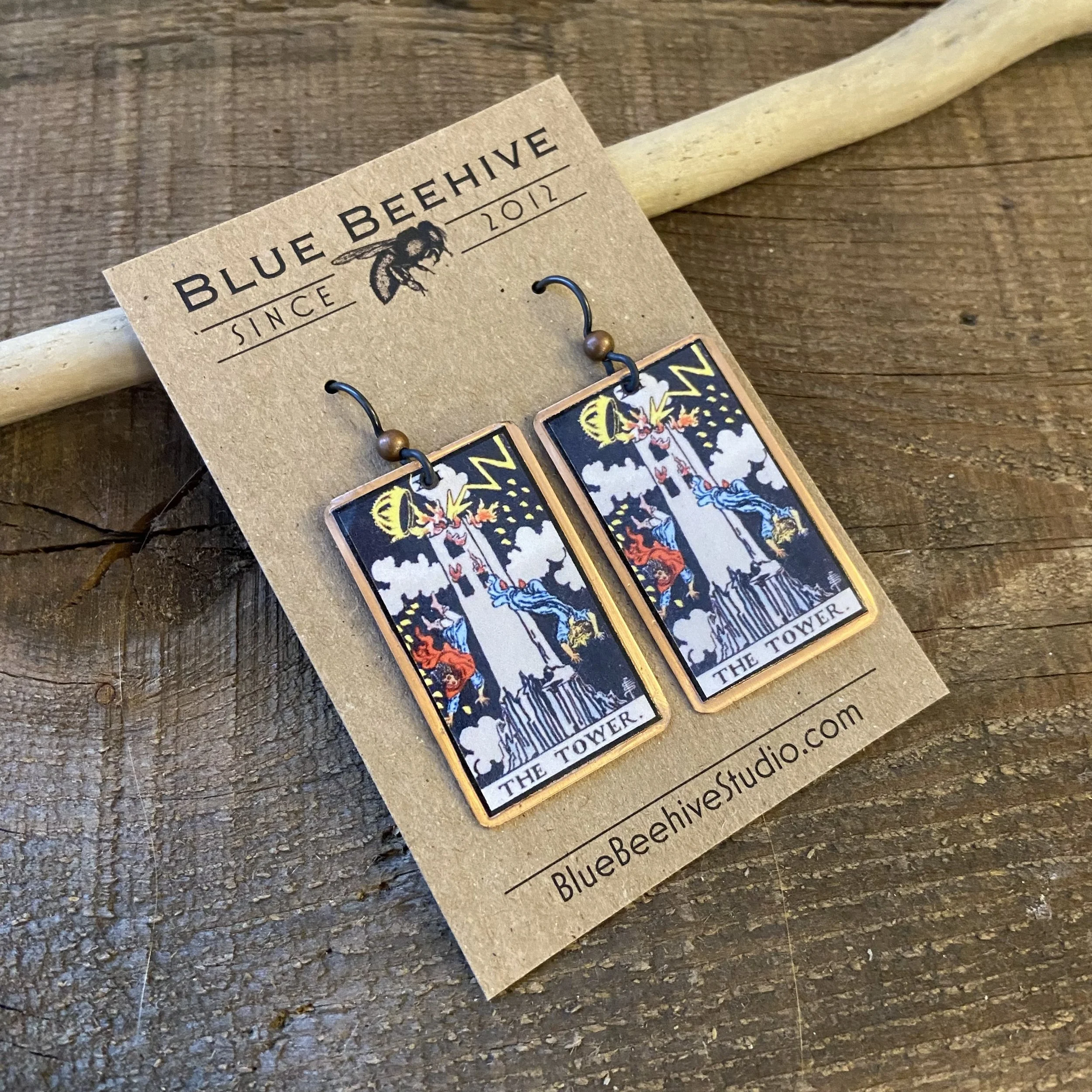 Picture of rectangular earrings of The Tower tarot card from the Rider-Waite Deck. Ear wires are black niobium with small copper balls.