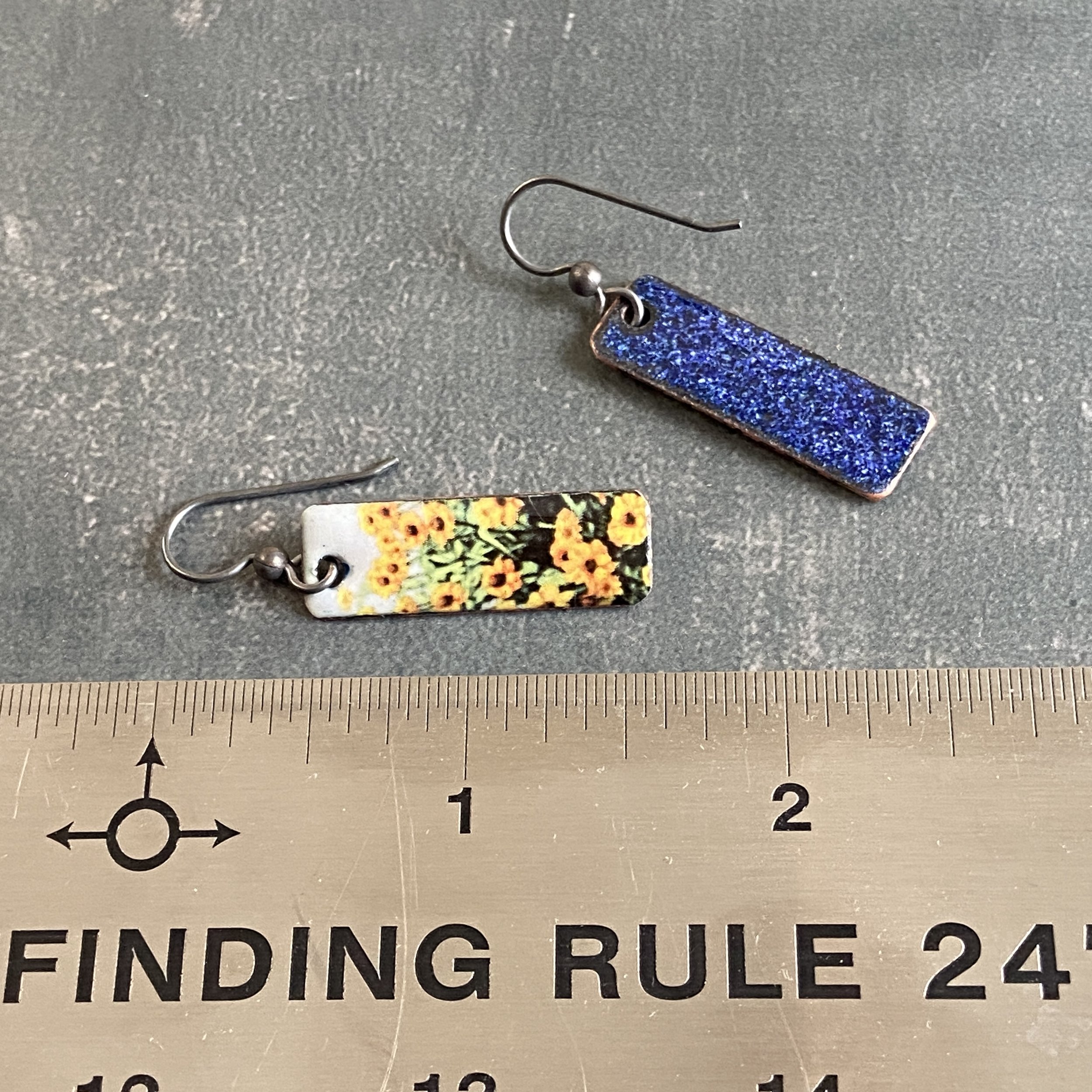 Rectangular enameled earrings featuring yellow zinnias in a field. Sterling silver ear wires.