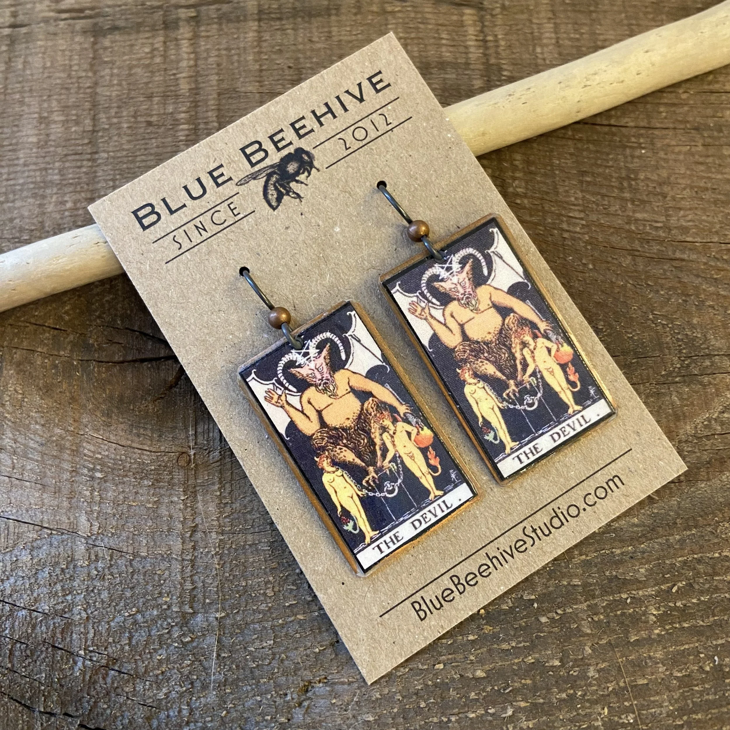 Picture of rectangular earrings of The Devil tarot card from the Rider-Waite Deck. Ear wires are black niobium with small copper balls.