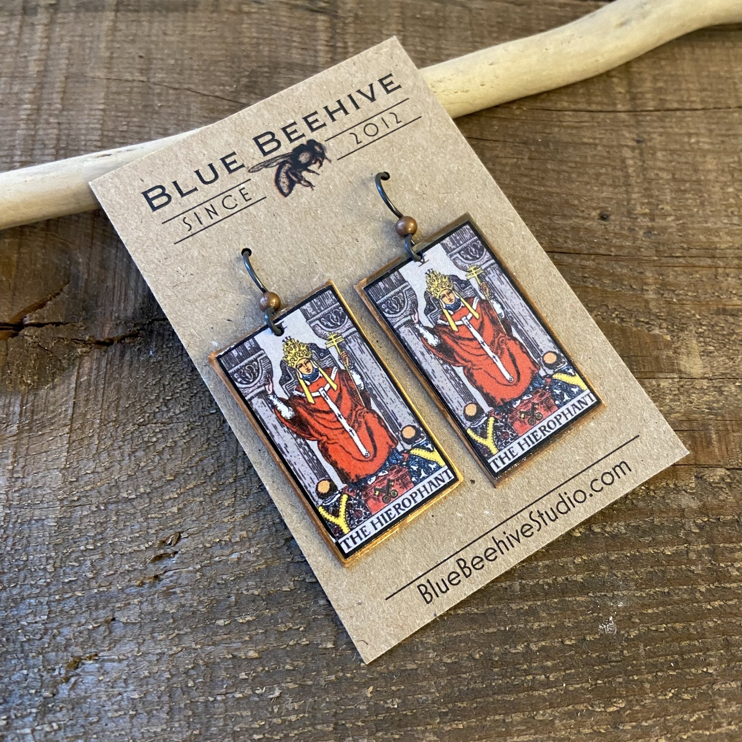 Picture of rectangular earrings of The Hierophant tarot card from the Rider-Waite Deck. Ear wires are black niobium with small copper balls.