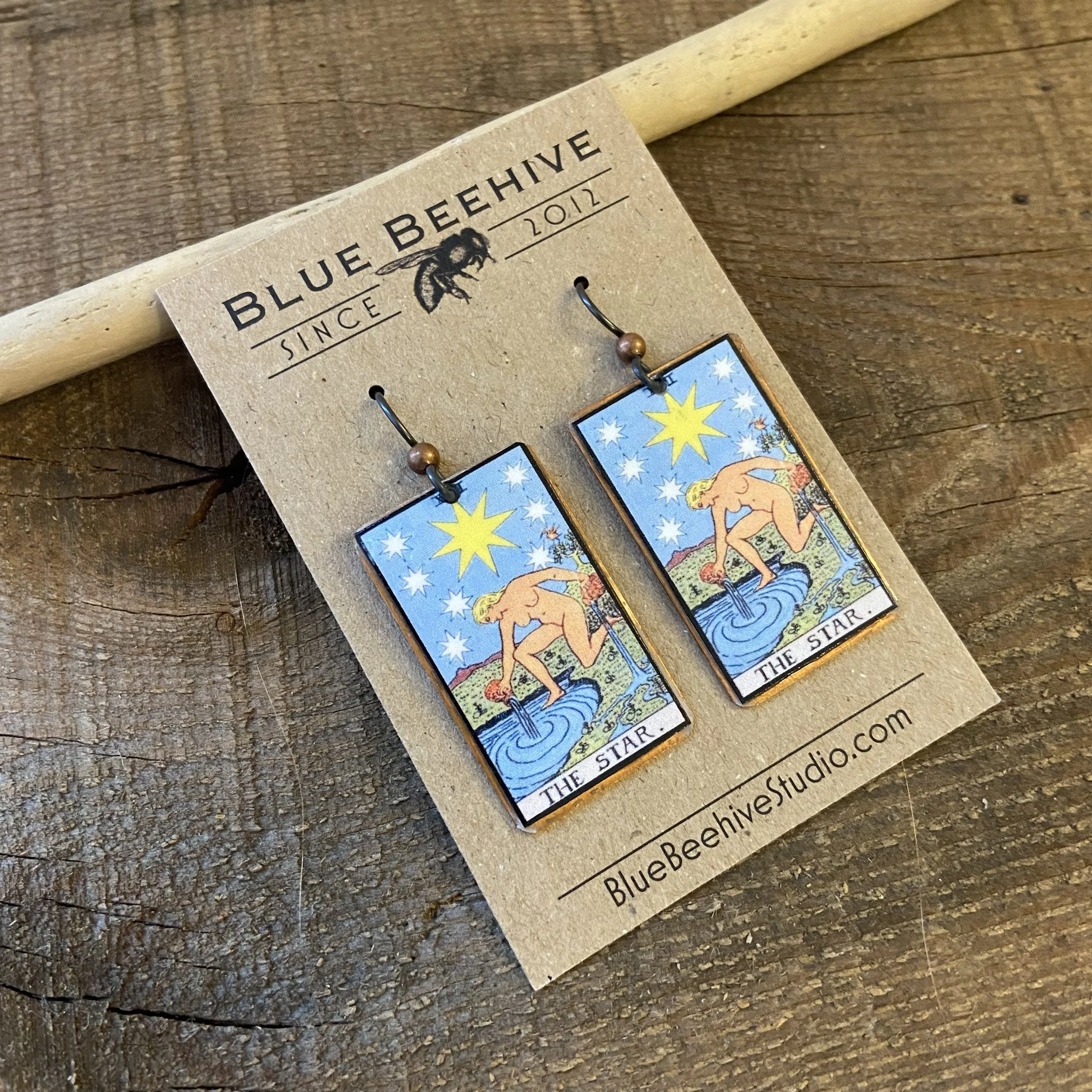 Picture of rectangular earrings of The Star tarot card from the Rider-Waite Deck. Ear wires are black niobium with small copper balls.
