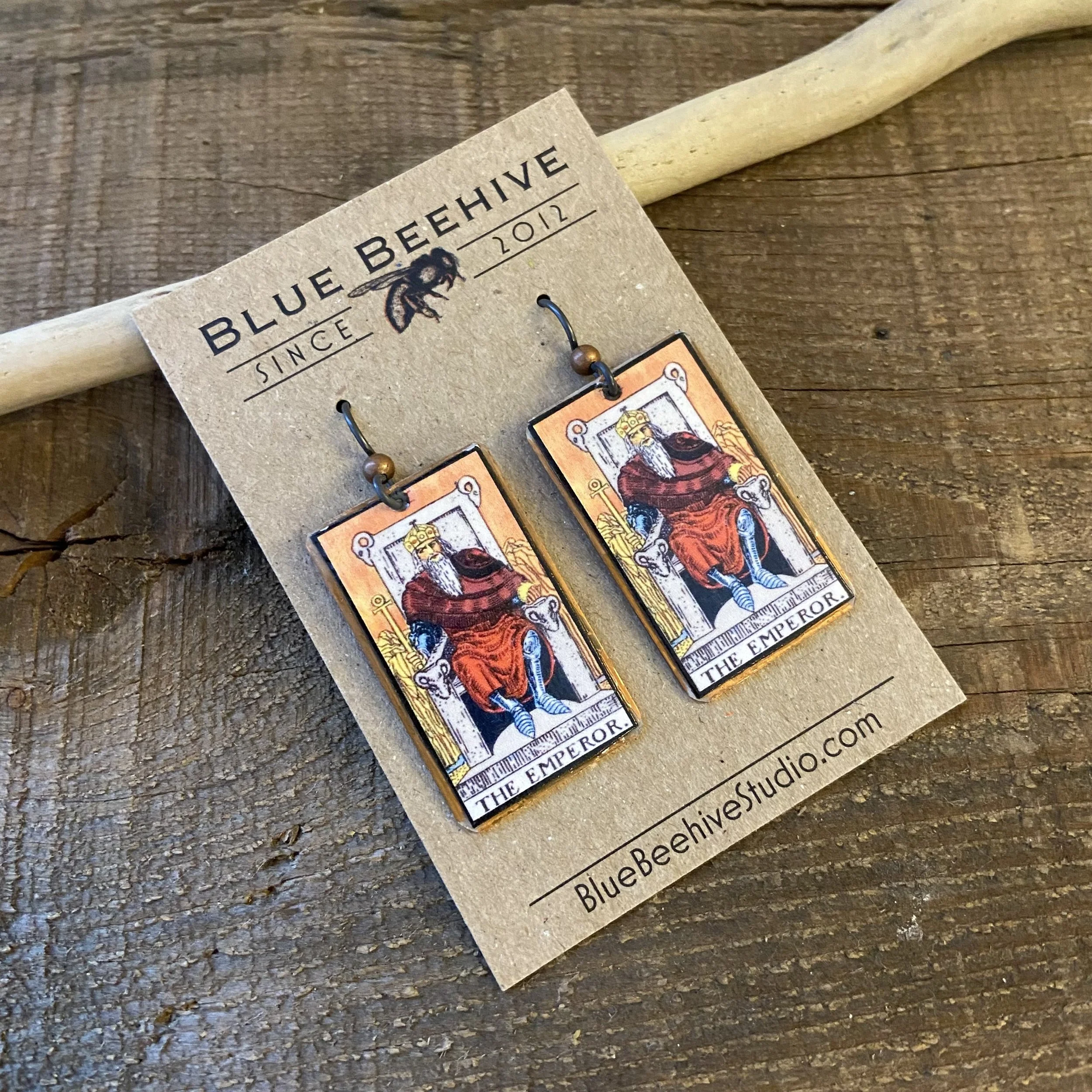 Picture of rectangular earrings of The Emperor tarot card from the Rider-Waite Deck. Ear wires are black niobium with small copper balls.