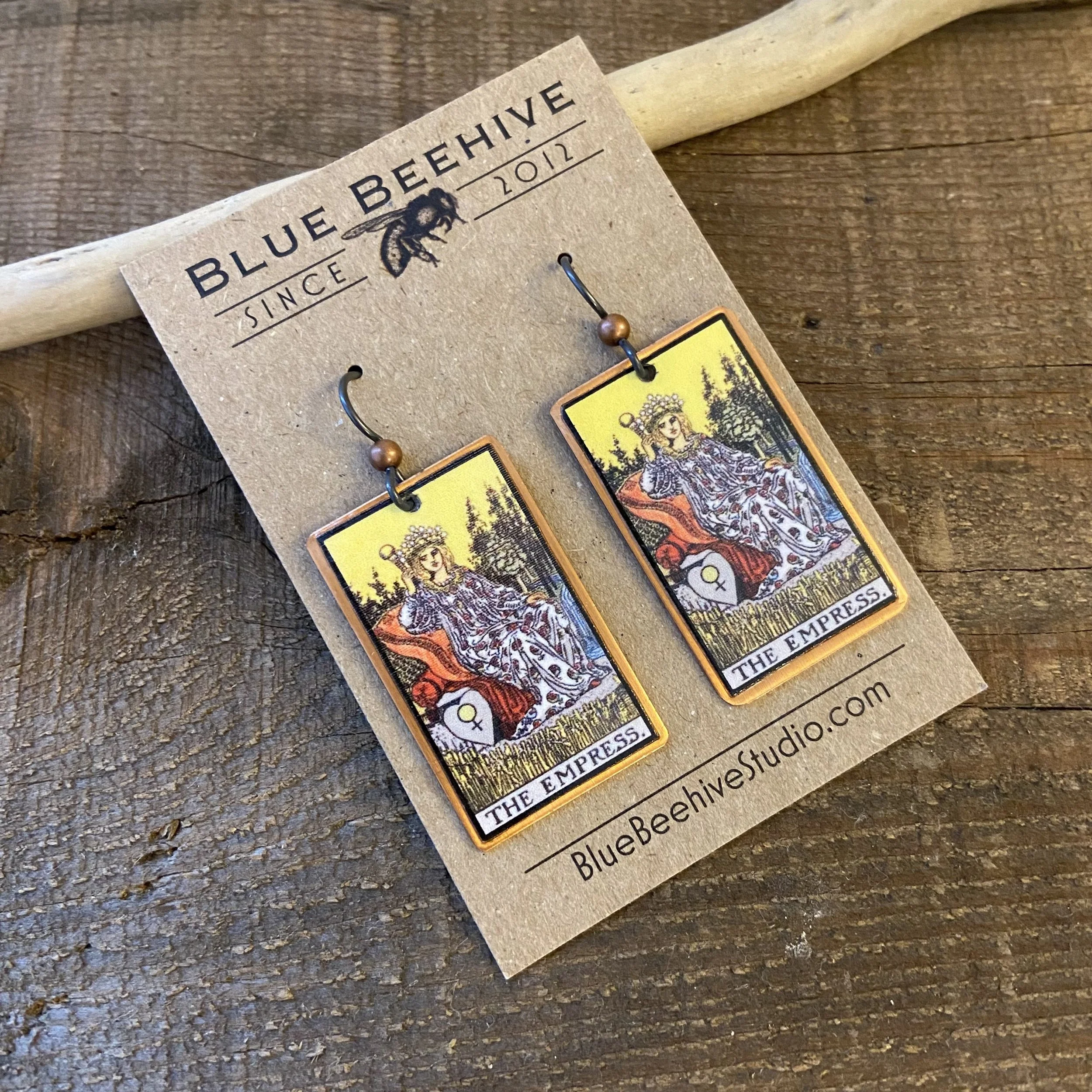 Picture of rectangular earrings of The Empress tarot card from the Rider-Waite Deck. Ear wires are black niobium with small copper balls.