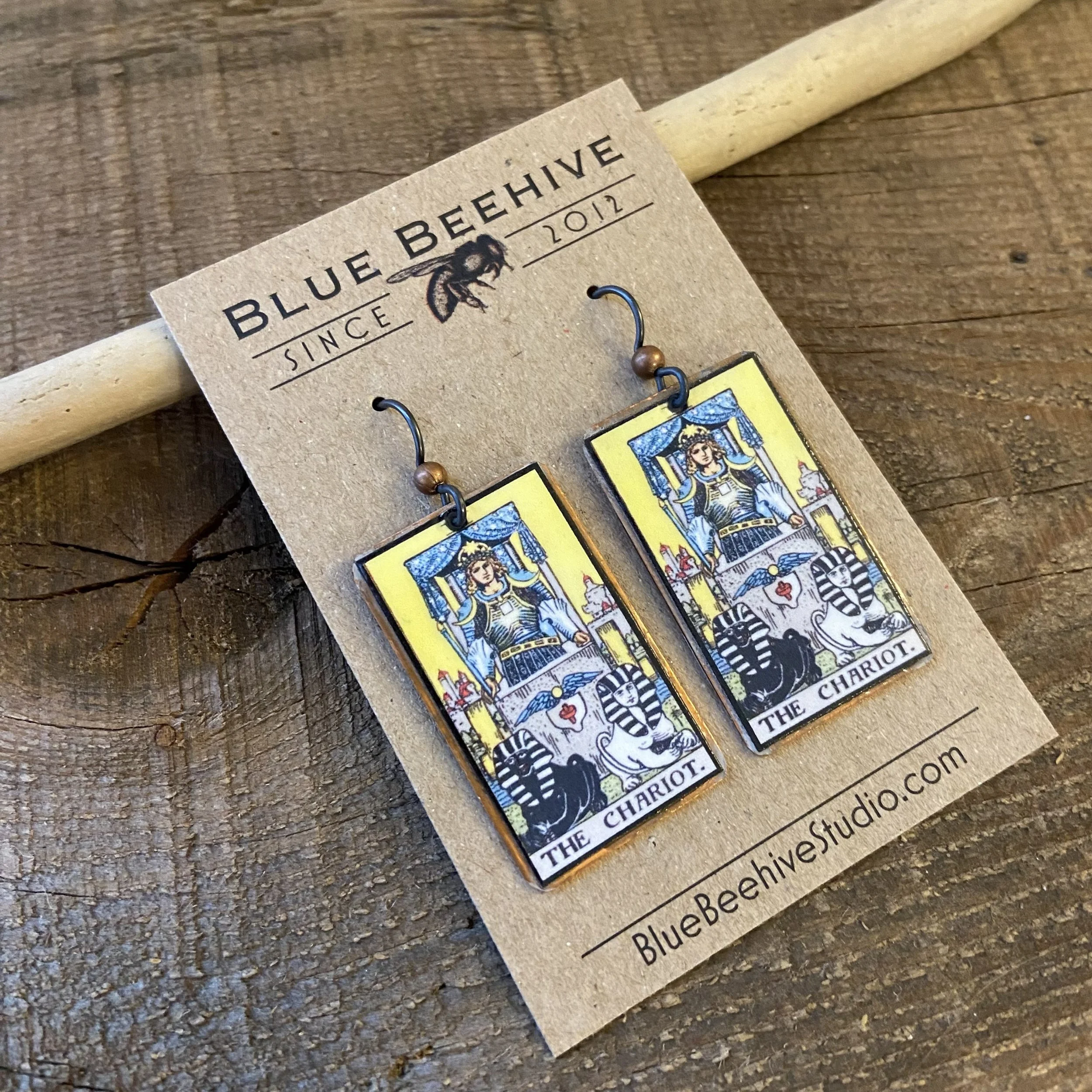 Picture of rectangular earrings of The Chariot tarot card from the Rider-Waite Deck. Ear wires are black niobium with small copper balls.
