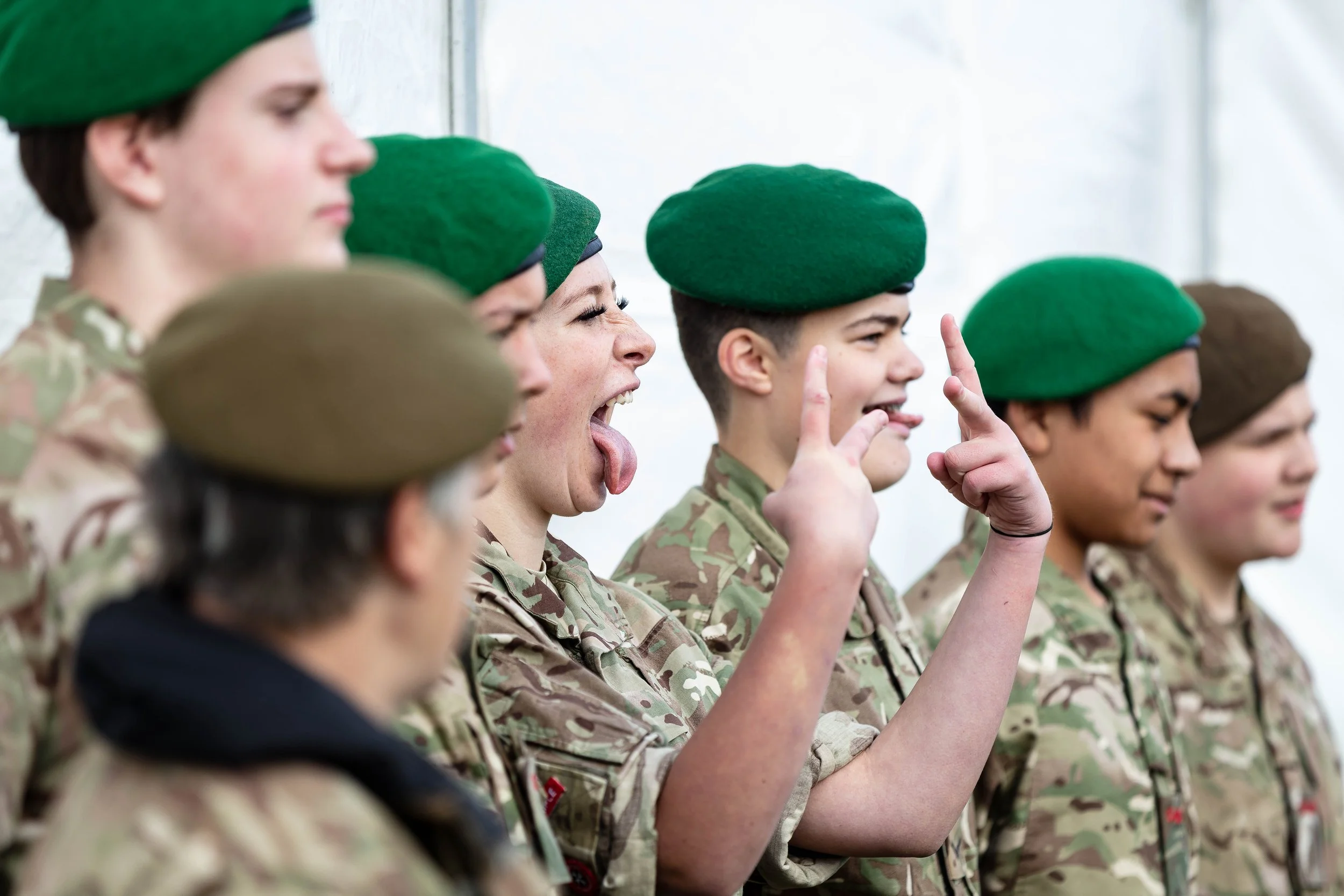 An army cadet breaks ranks and chucks the V's at another photographer taking a group picture
