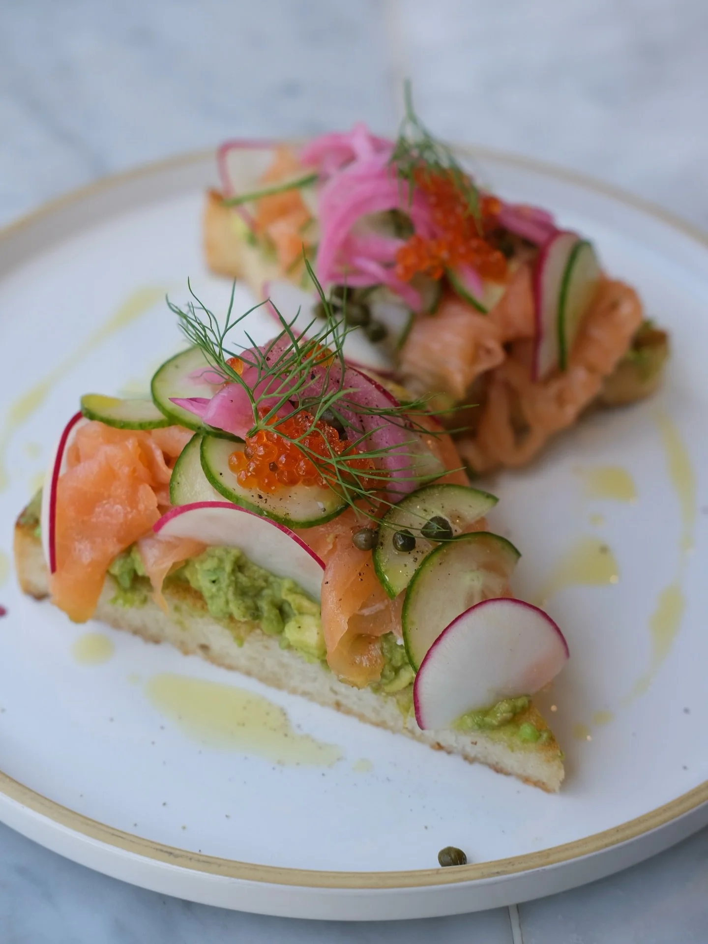 &ldquo;Holy Smokes!&rdquo; Our newest take on avocado toast features avocado, smoked salmon, trout roe, pickled red onions, cucumber, radish, and capers 🥑🩷 typically comes on our einkorn sourdough toast, but seen here on our Gluten Free bread (made