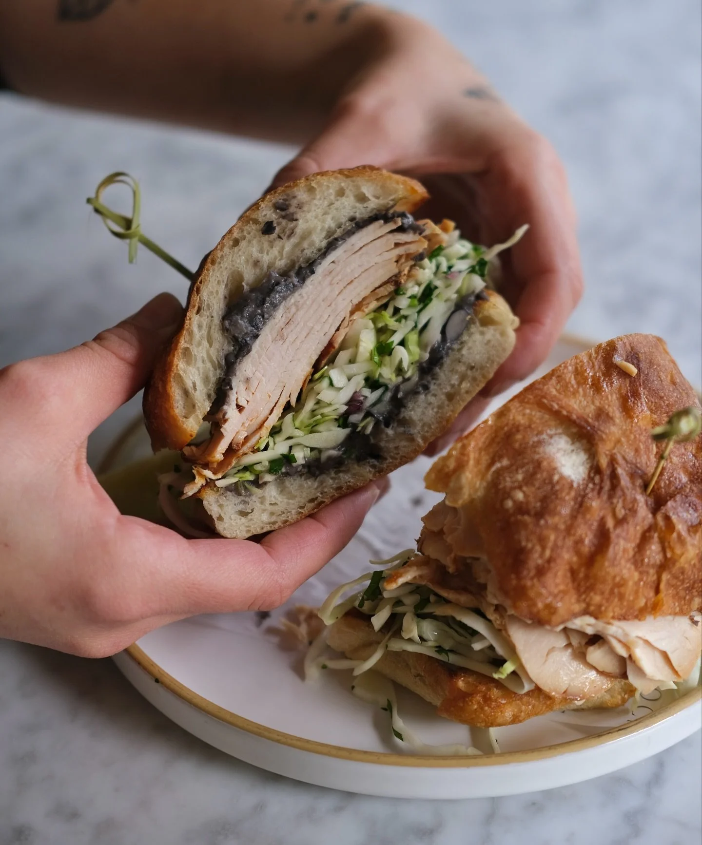 Holy moly! Spotlighting the Turkey Mole Sandwich // mole marinated turkey, cilantro slaw, pickled red onion, refried bean spread, served on ciabatta (GFO) 🌾🤍
