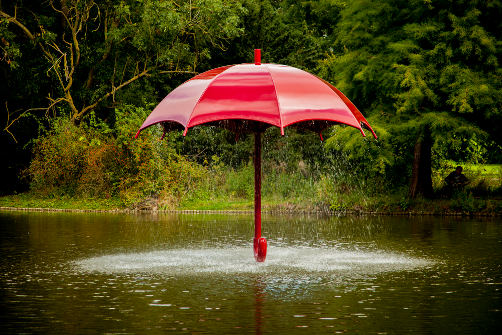 The red umbrella in the Julianapark in Leeuwarden, with water pouring down from underneath it.