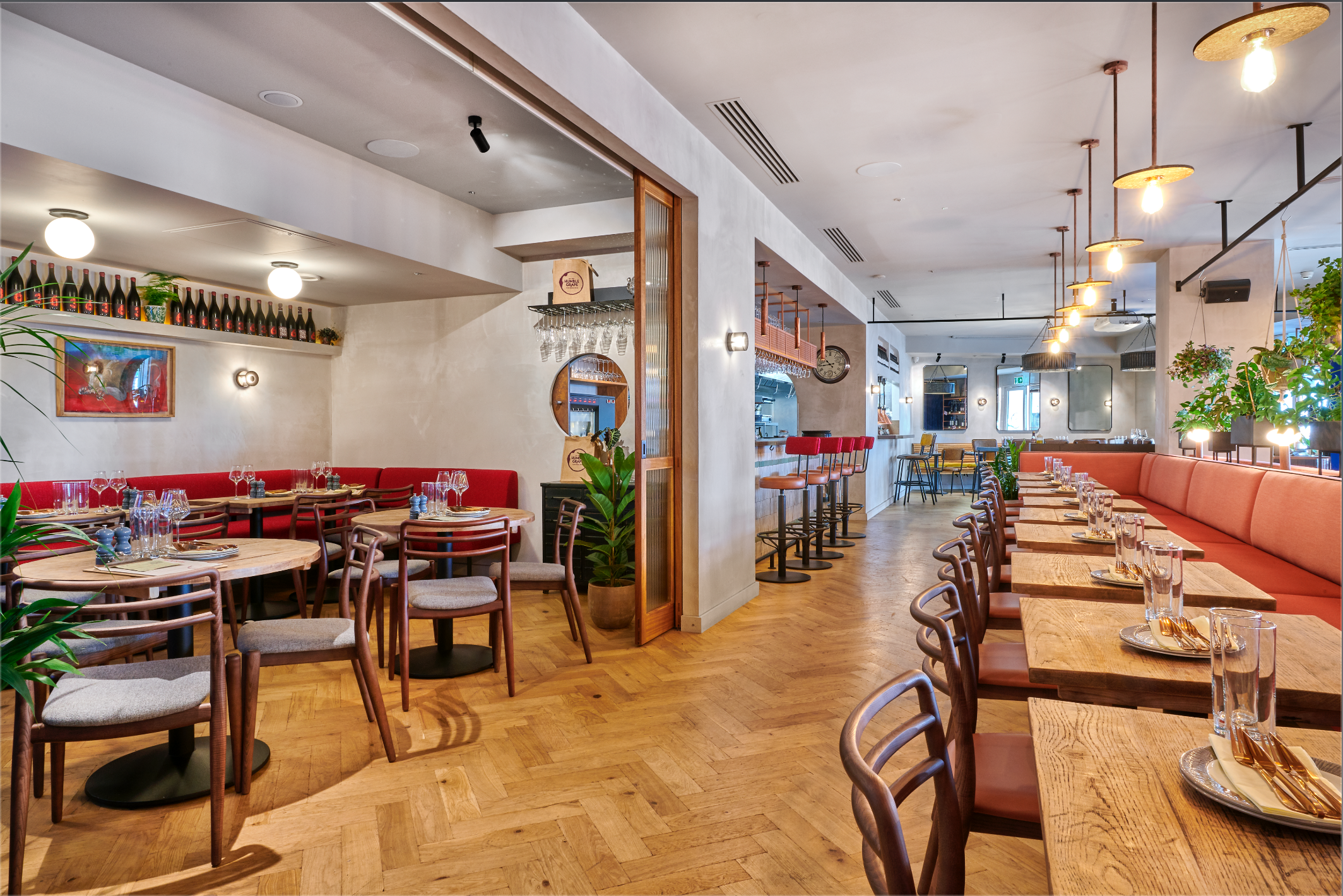 Interior view through the sliding doors between the Humble Grape Canary Wharf main floor and private dining room