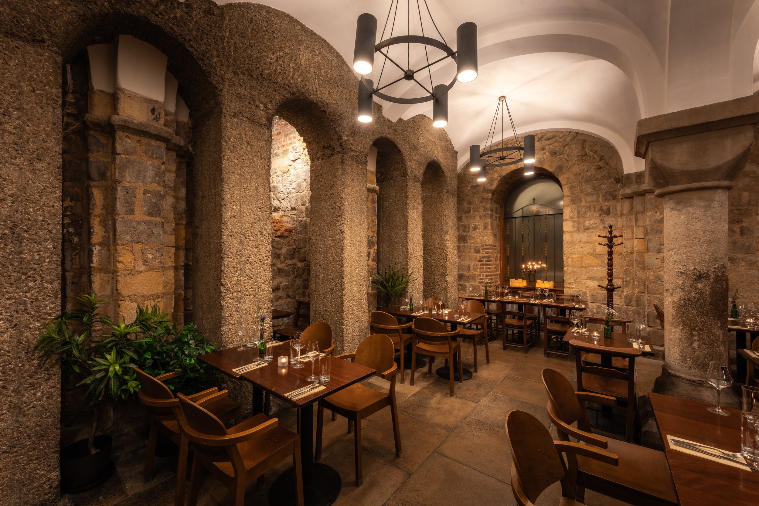 Candlelit tables inside the Humble Grape Bow Lane crypt, stone arches and vaulted ceiling visible
