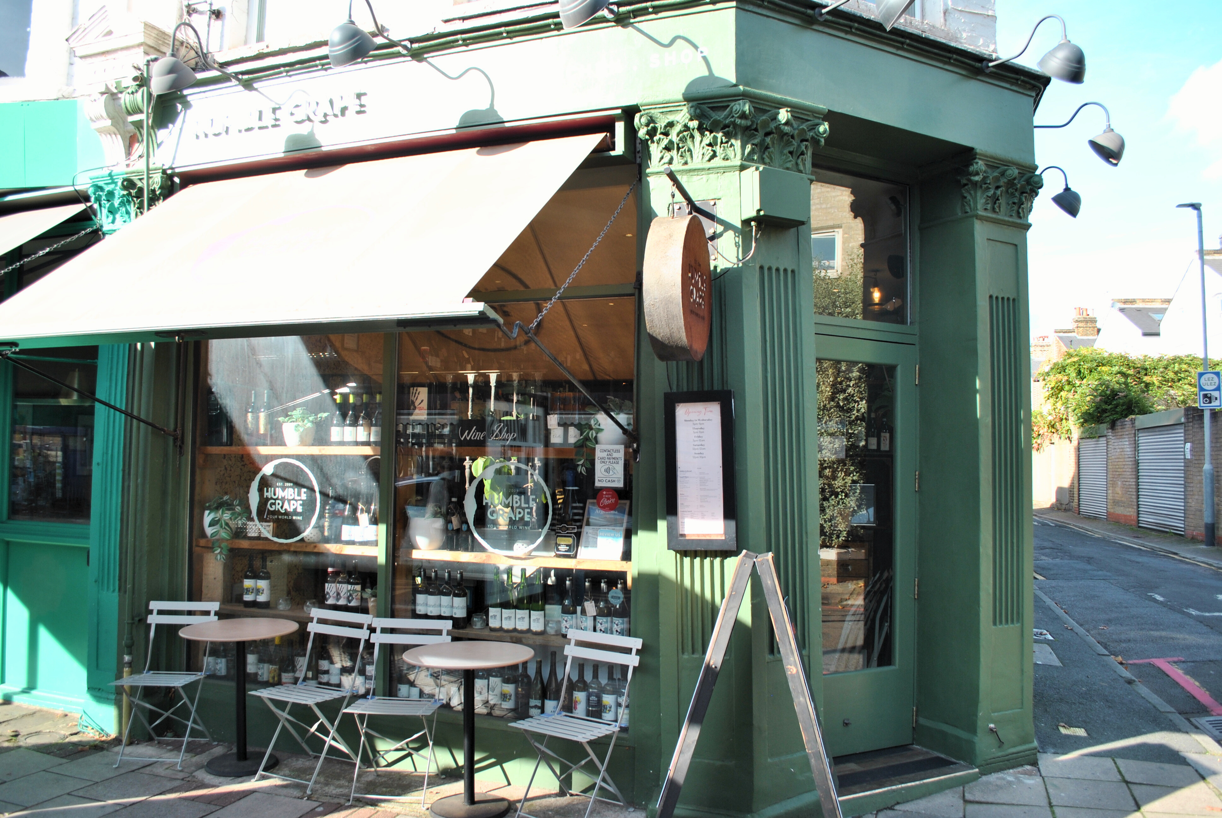 The Humble Grape Battersea shopfront, with outdoor tables and a wine-shop window display.