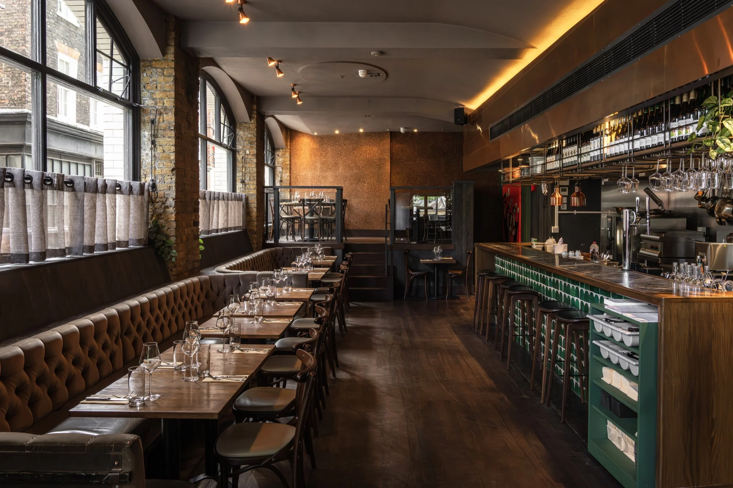 The Humble Grape Smithfield wine bar, with its emerald bar, exposed brick and arched windows.