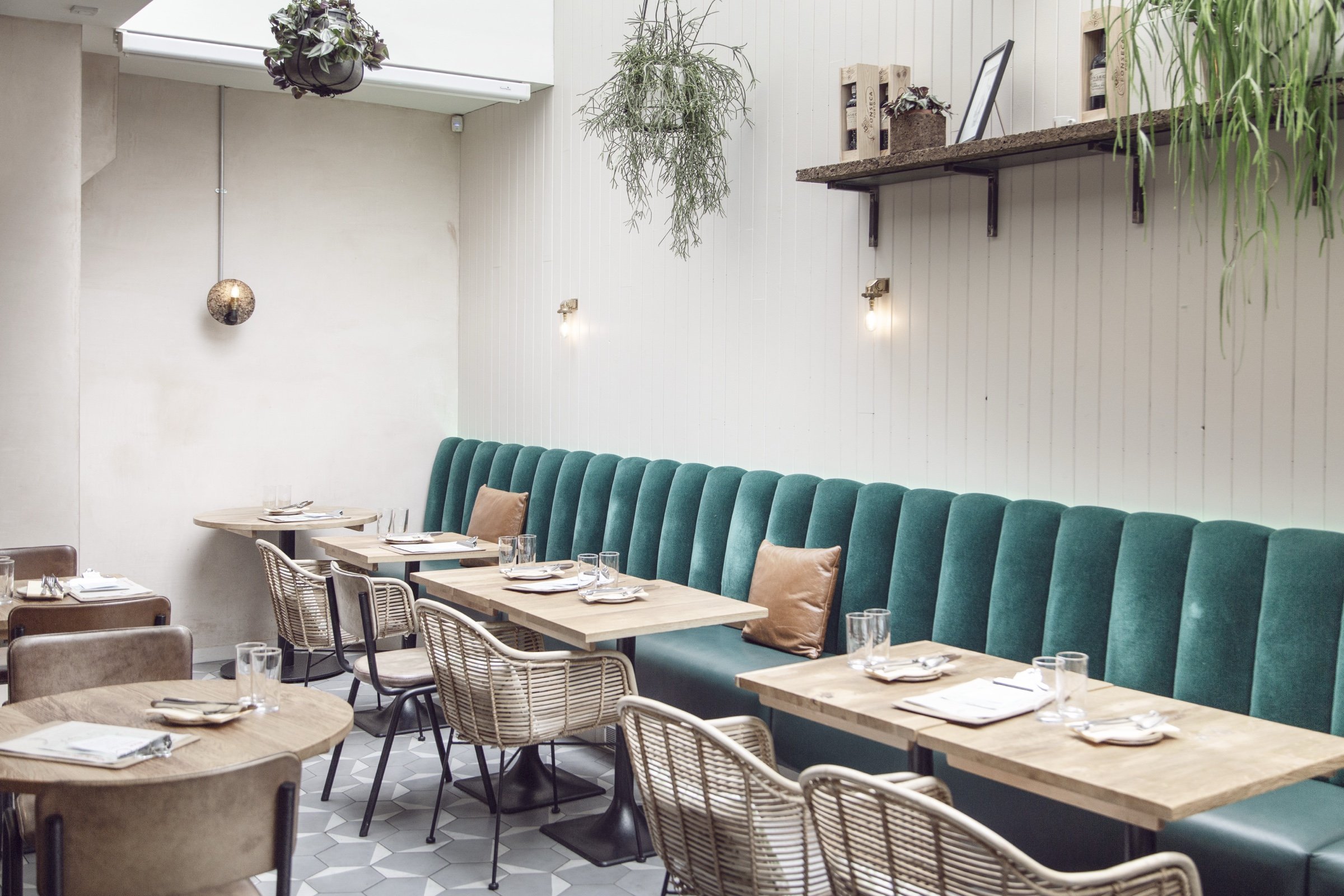 The dining room at Humble Grape Islington, with tables set beneath pendant lights.