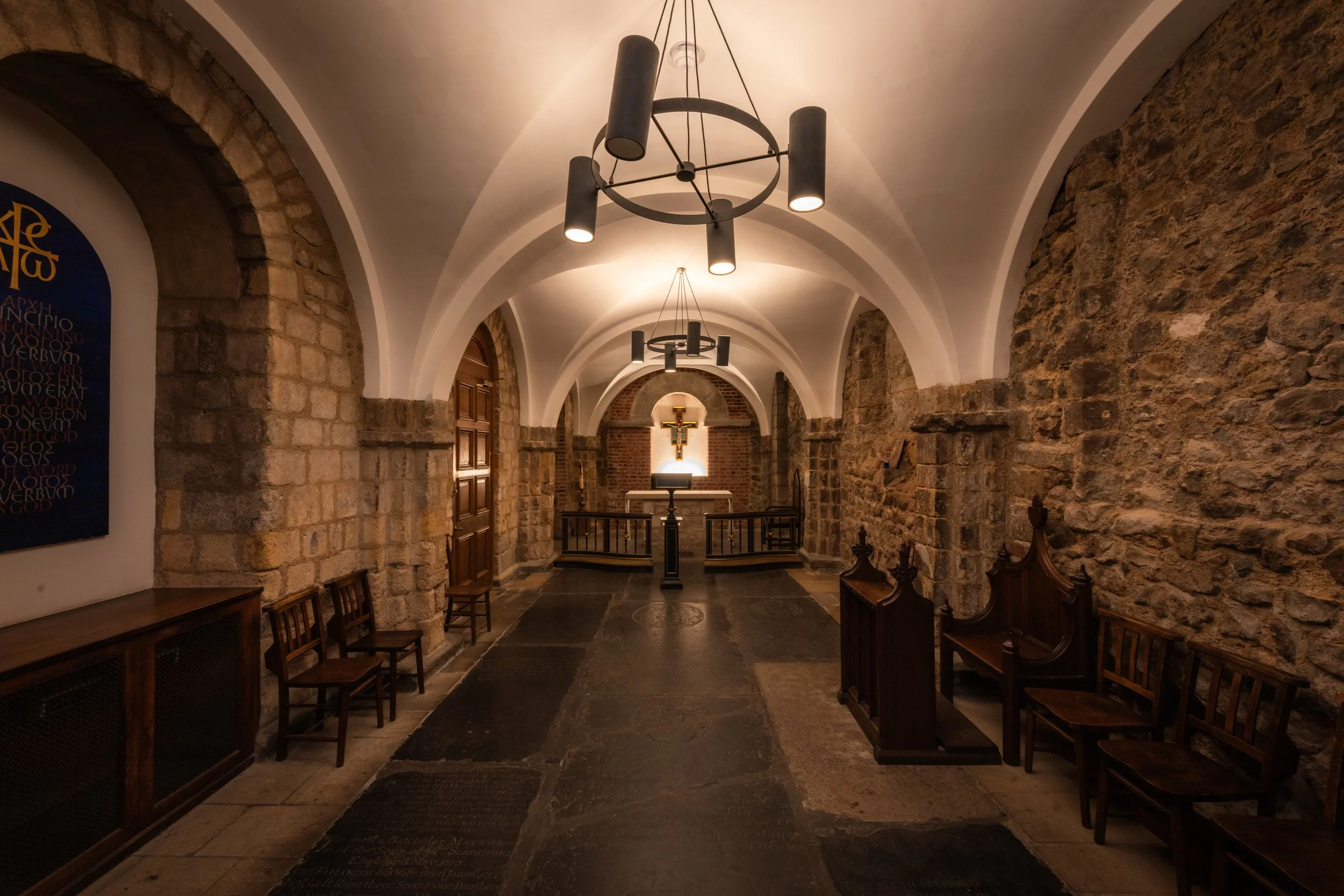 The Chapel at Humble Grape Bow Lane, with stone walls, arched ceilings and an altar at the end of the room.