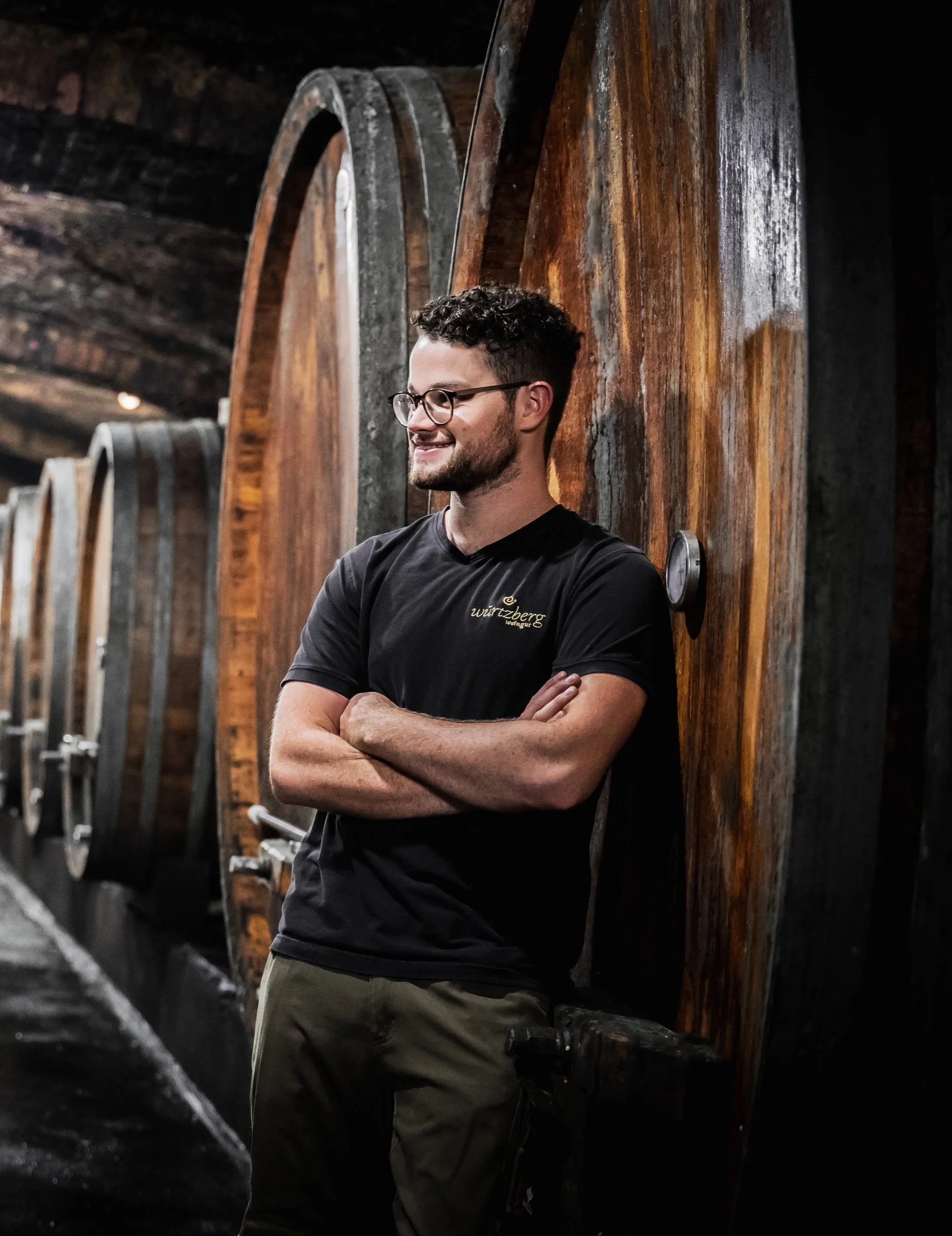 Winemaker Felix Heimes beside wooden barrels in the Weingut Würtzberg cellar.