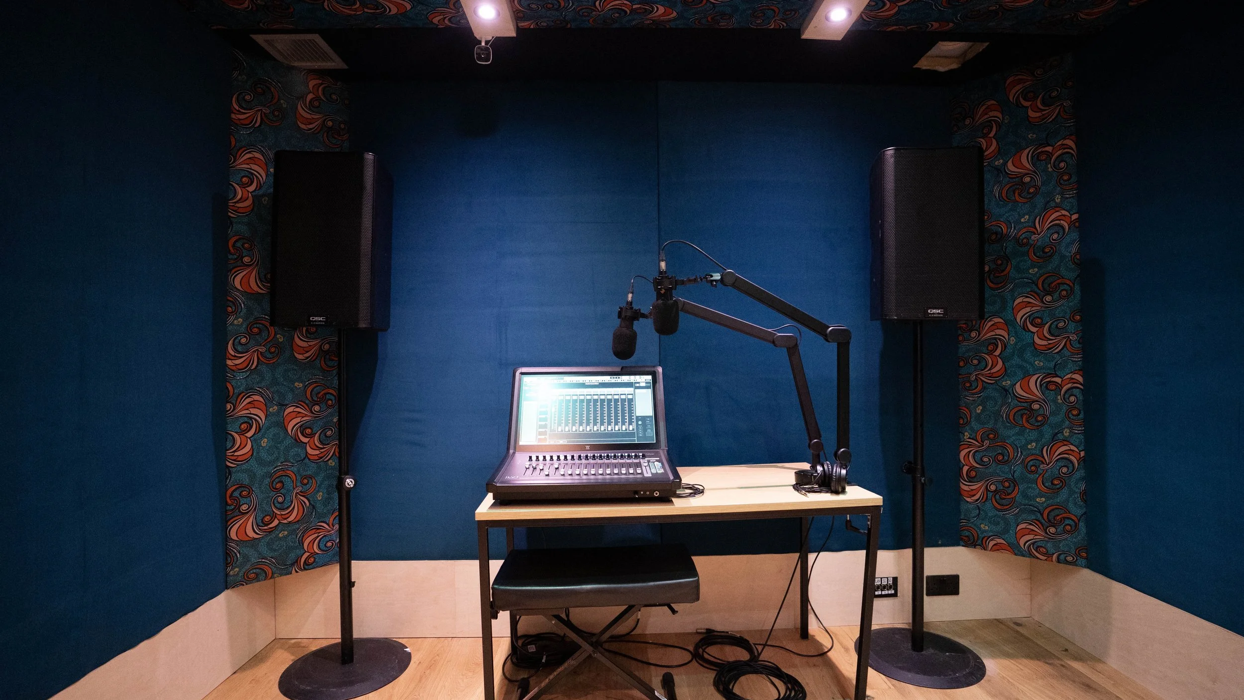 Studio 13 podcast desk with microphones and monitors
