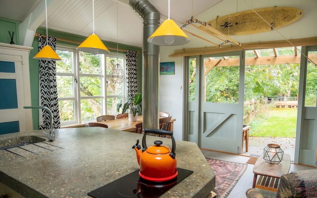 open plan kitchen sitting room with log fire and views of trees