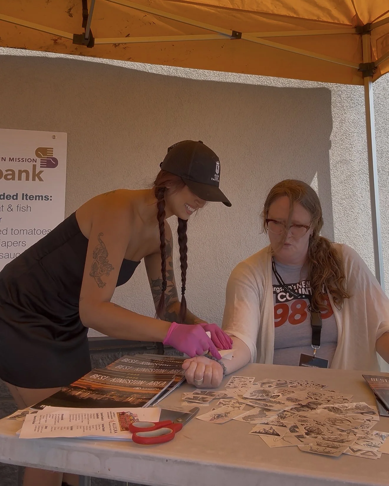 Lakeside's Leesh putting a temporary tattoo on 102.7's Trinette at the Food Drive!