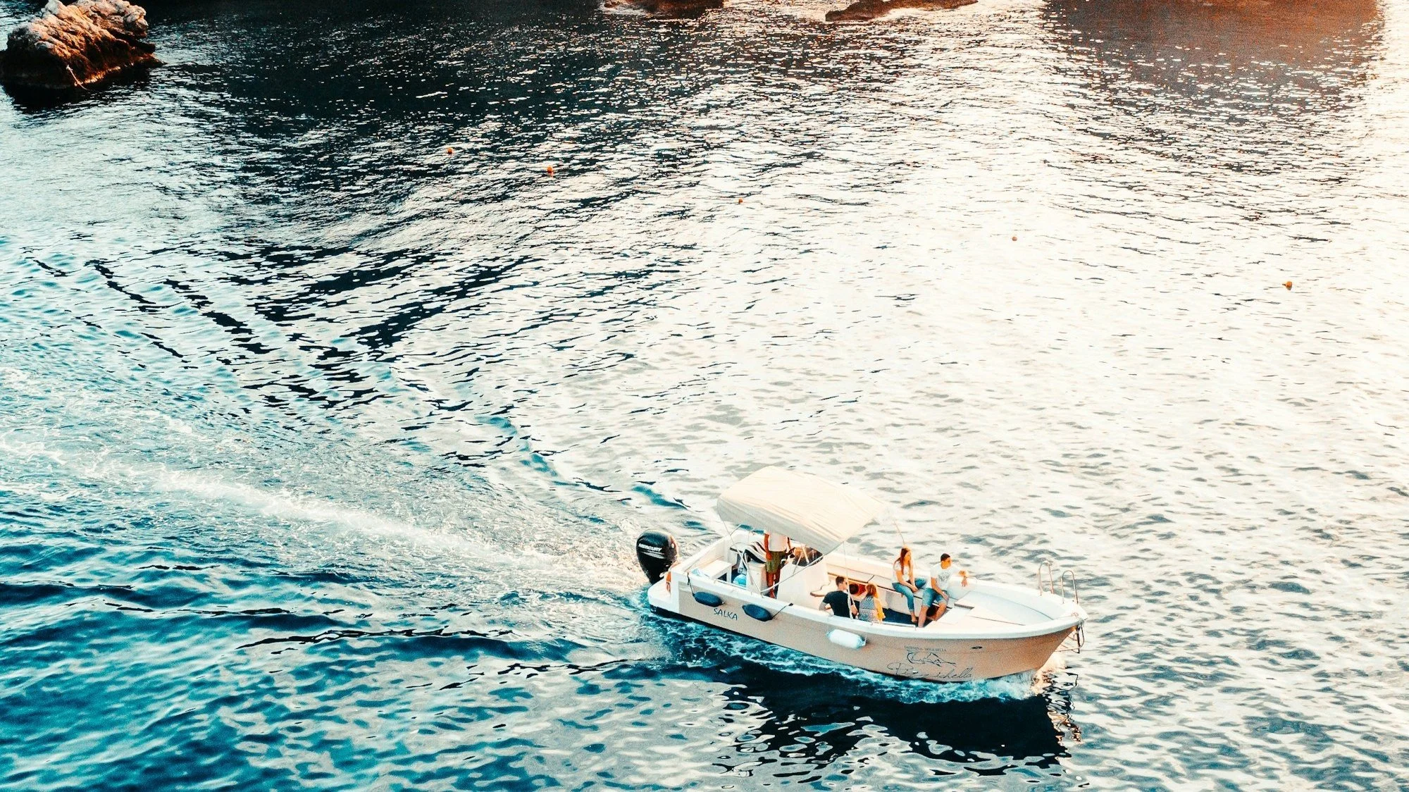 A group of individuals enjoys a leisurely ride on a boat, gliding across the calm surface of the water.