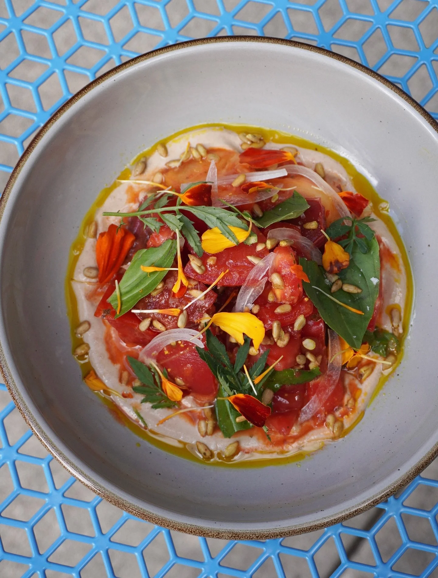 Goodbye tomato season 🥲 saying farewell to our Heirloom Tomato Salat this weekend.

The most beautiful end of season maters, sunflower seed tehina, adjika sunflower seeds, basil, sweet onion, and marigold oil. ✨ 

Until next time... 🍅🍅🍅