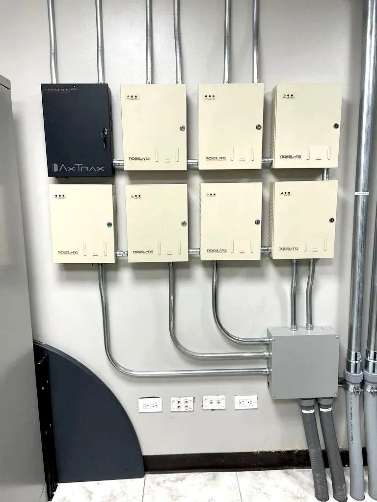 Cuadros eléctricos y cables en una pared, con enchufes y conexiones eléctricas.