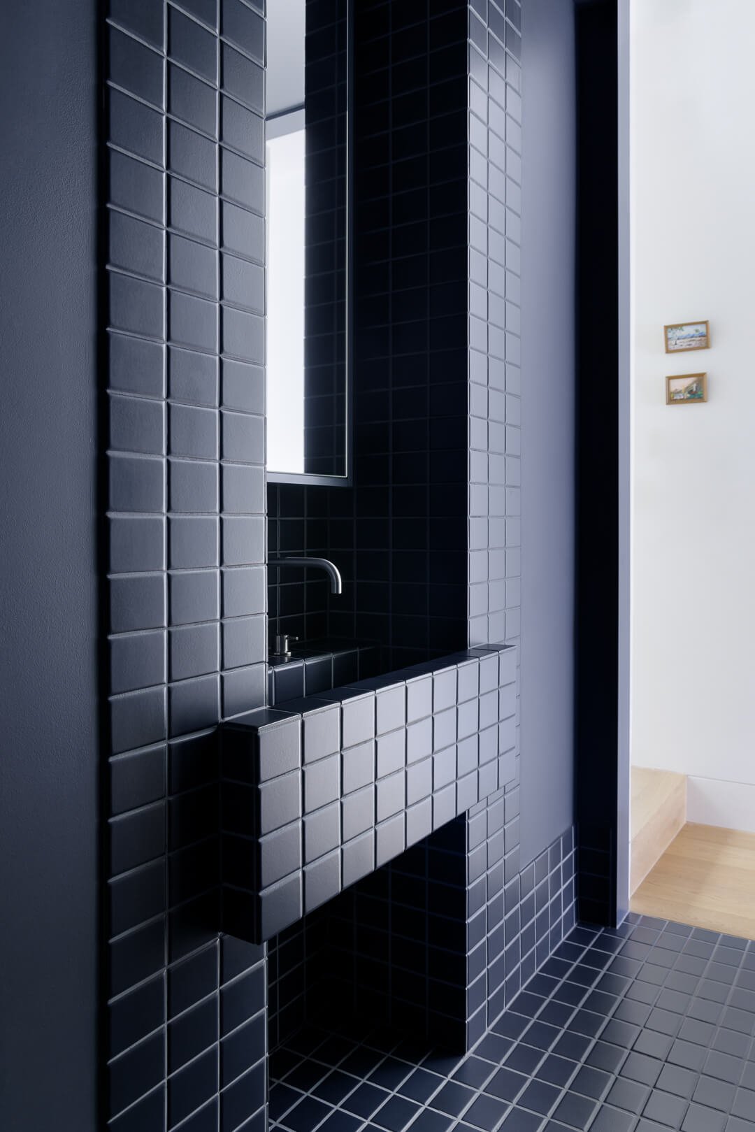 Bold monochromatic bathroom at Silver House featuring navy blue square tiles and a matching tiled vanity by By Mysa.