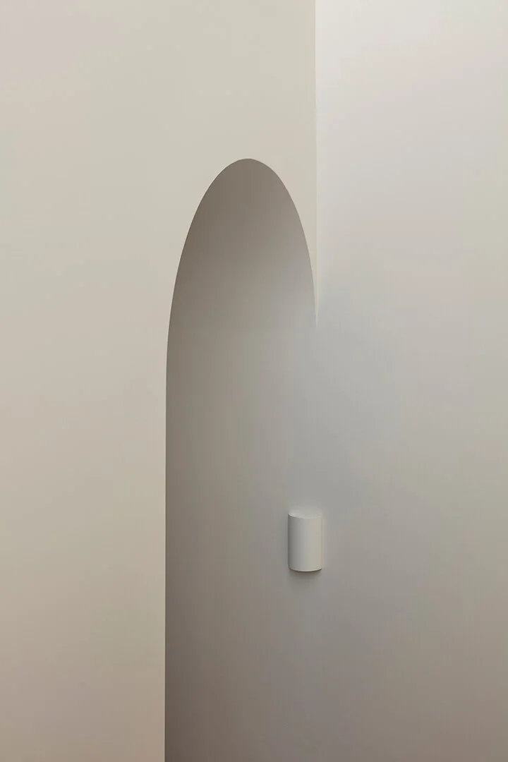 Feature archway, with a sleek modern wall light.