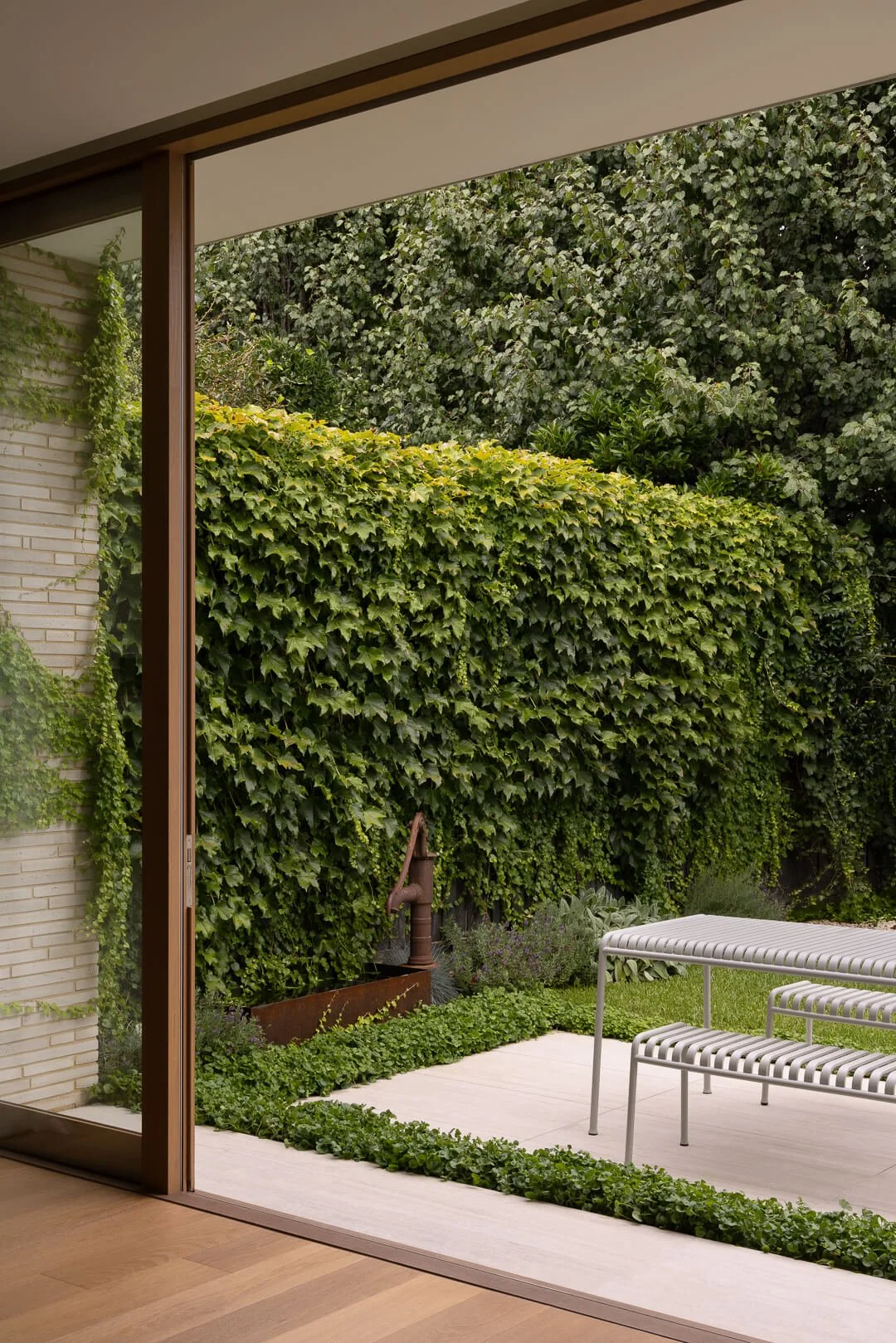 View from the modern living zone toward the unstructured garden, highlighting the balance of order and organic growth.