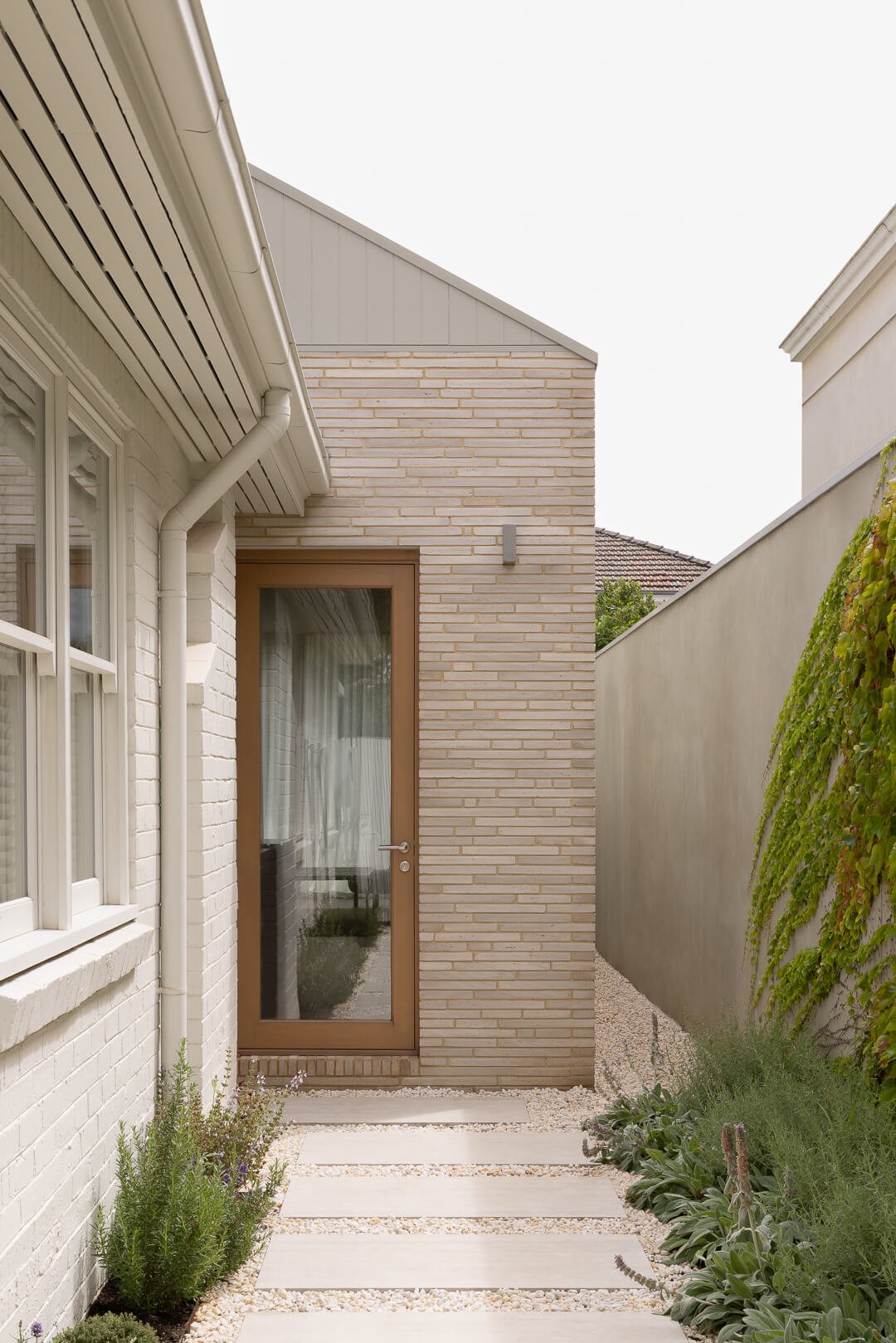 Material detail at Silver House: Slim-profile brickwork and timber-framed glass door by By Mysa.