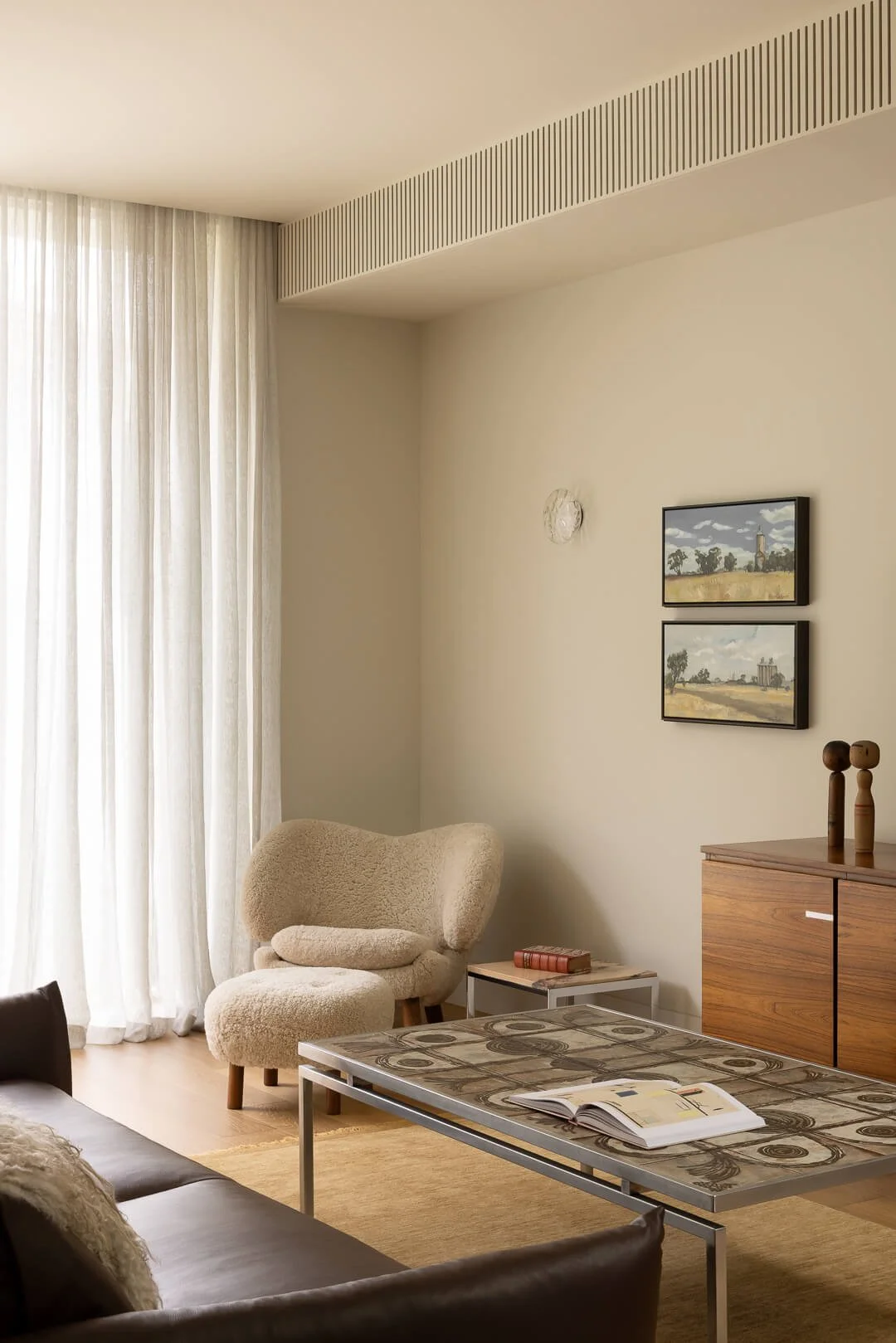 House of Finn Juhl Sheepskin Pelican Chair and ottoman in a modern living space with timber mid-century furniture at Silver House.