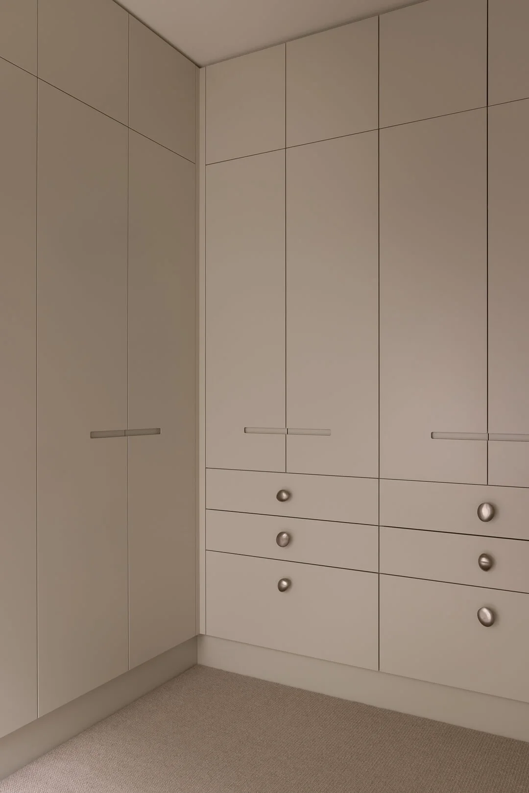 Custom corner wardrobe joinery with minimalist hardware and a soft tonal palette at Silver House.