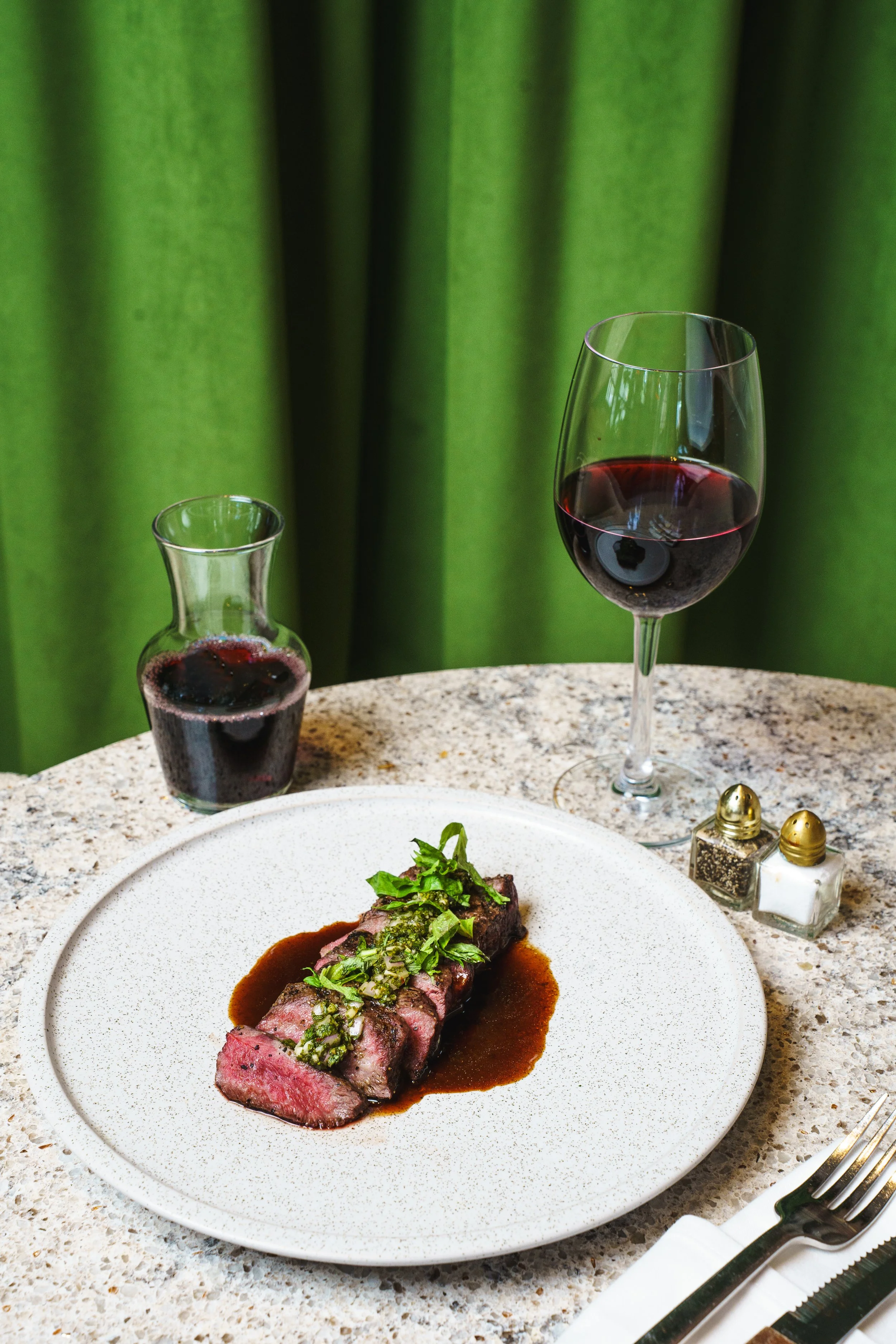 A plate of styled food and wine.